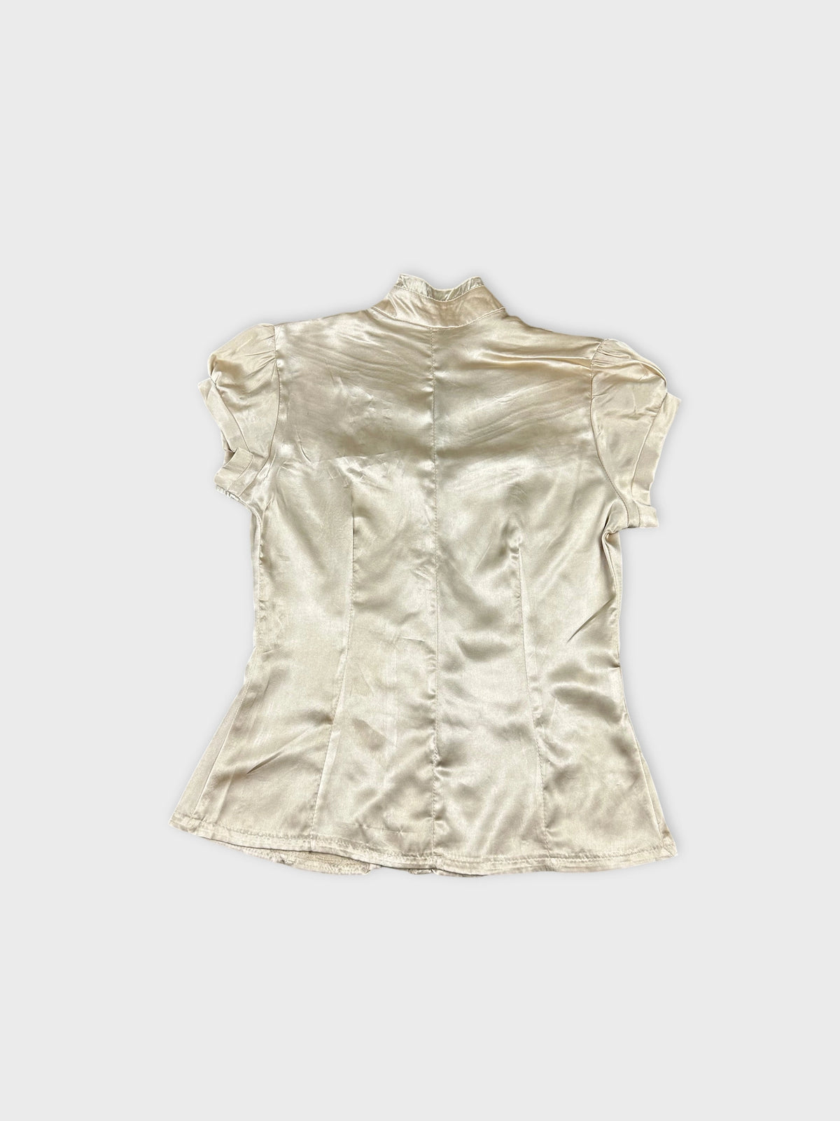 Detail view of a short sleeve button-up shirt in cream with a fitted shape.