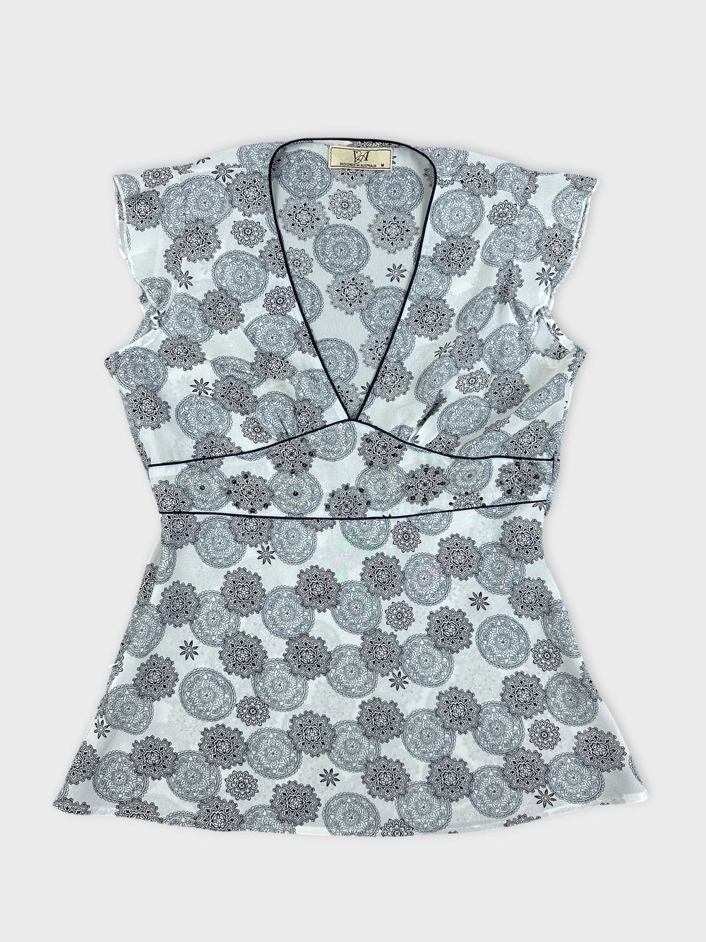 Front view of a women short sleeve top in white with floral pattern.
