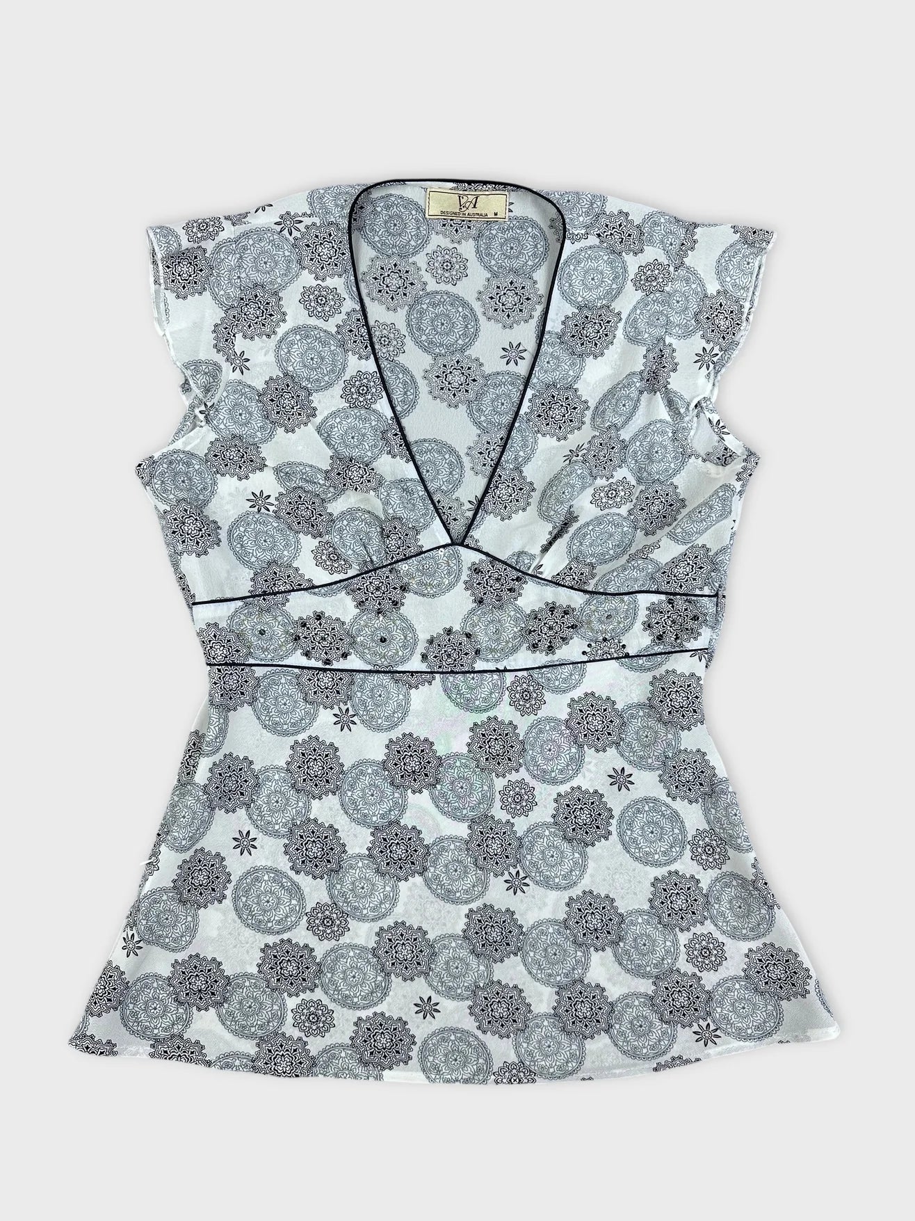 Front view of a women short sleeve top in white with floral pattern.