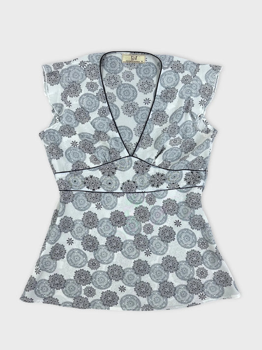 Front view of a women short sleeve top in white with floral pattern.