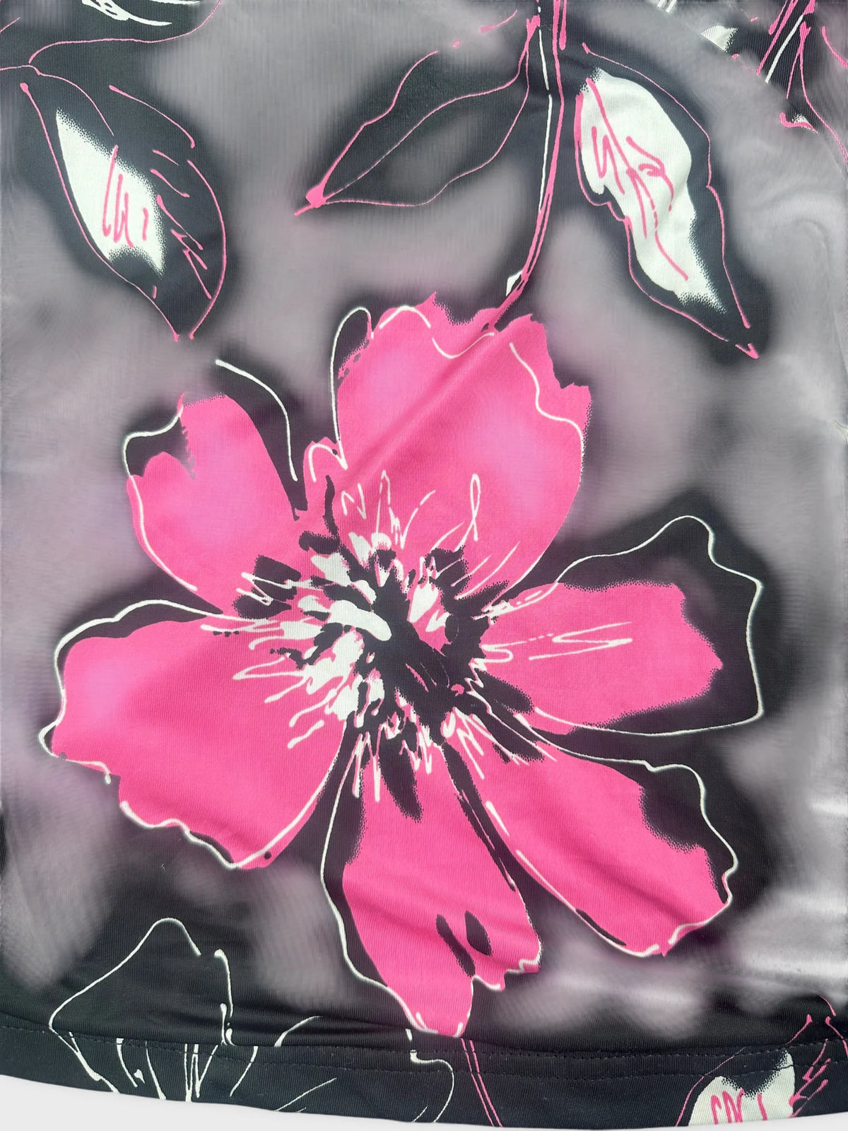 Detail view of a short top featuring pink floral print on a dark background.