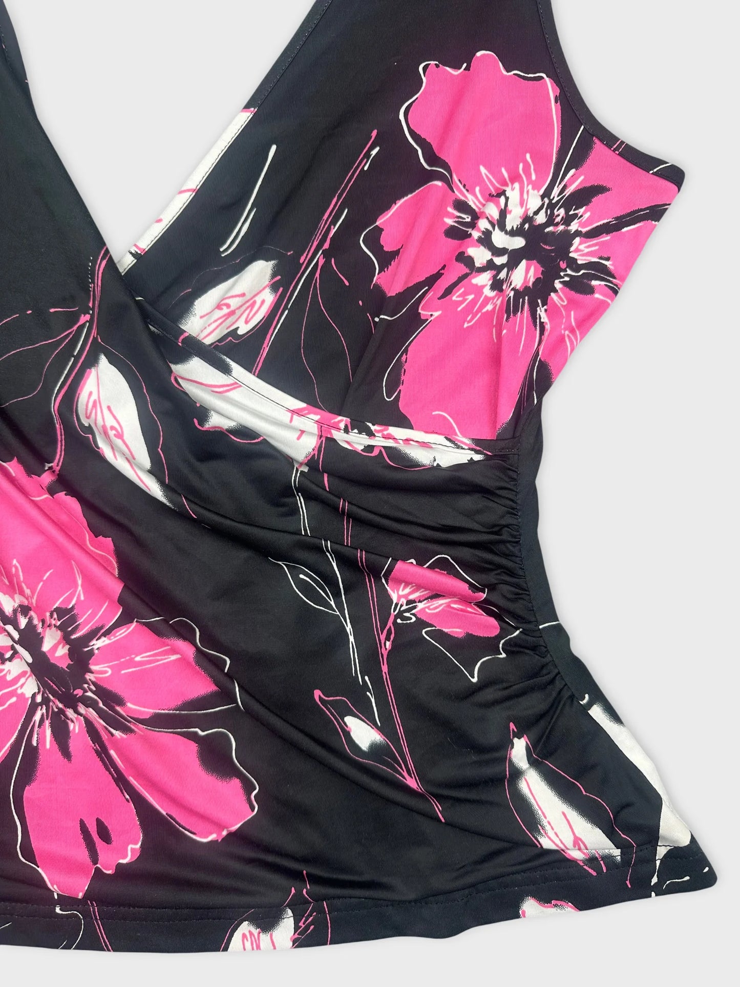 Detail view of a black sleeveless top with pink floral print.