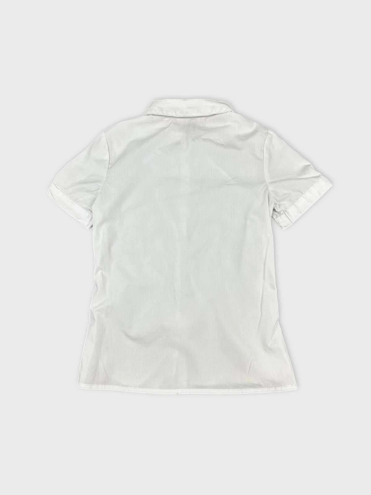 Back view of women's short sleeve white shirt with folded sleeves.