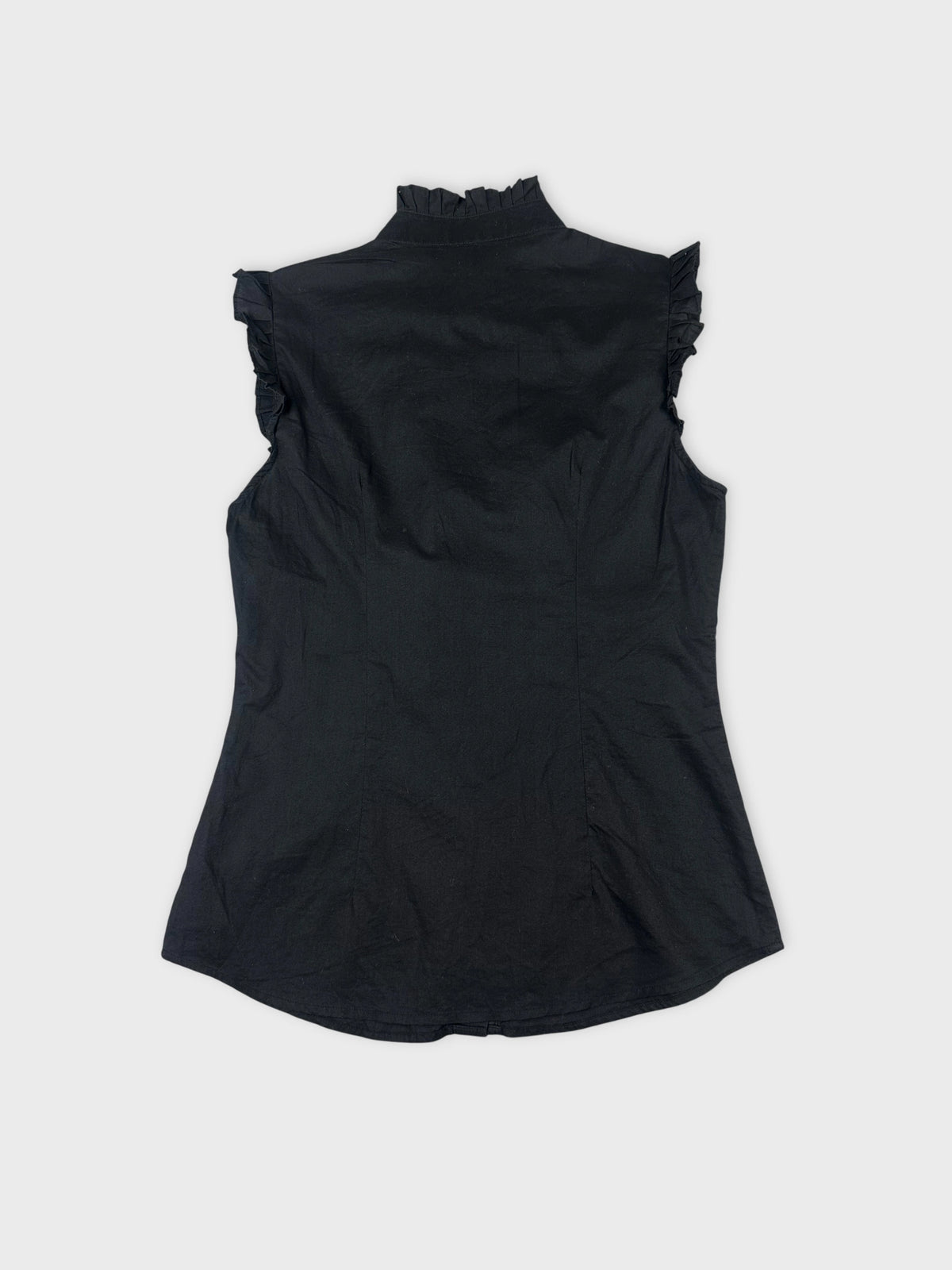 Back view of a black sleeveless shirt with ruffled trim.
