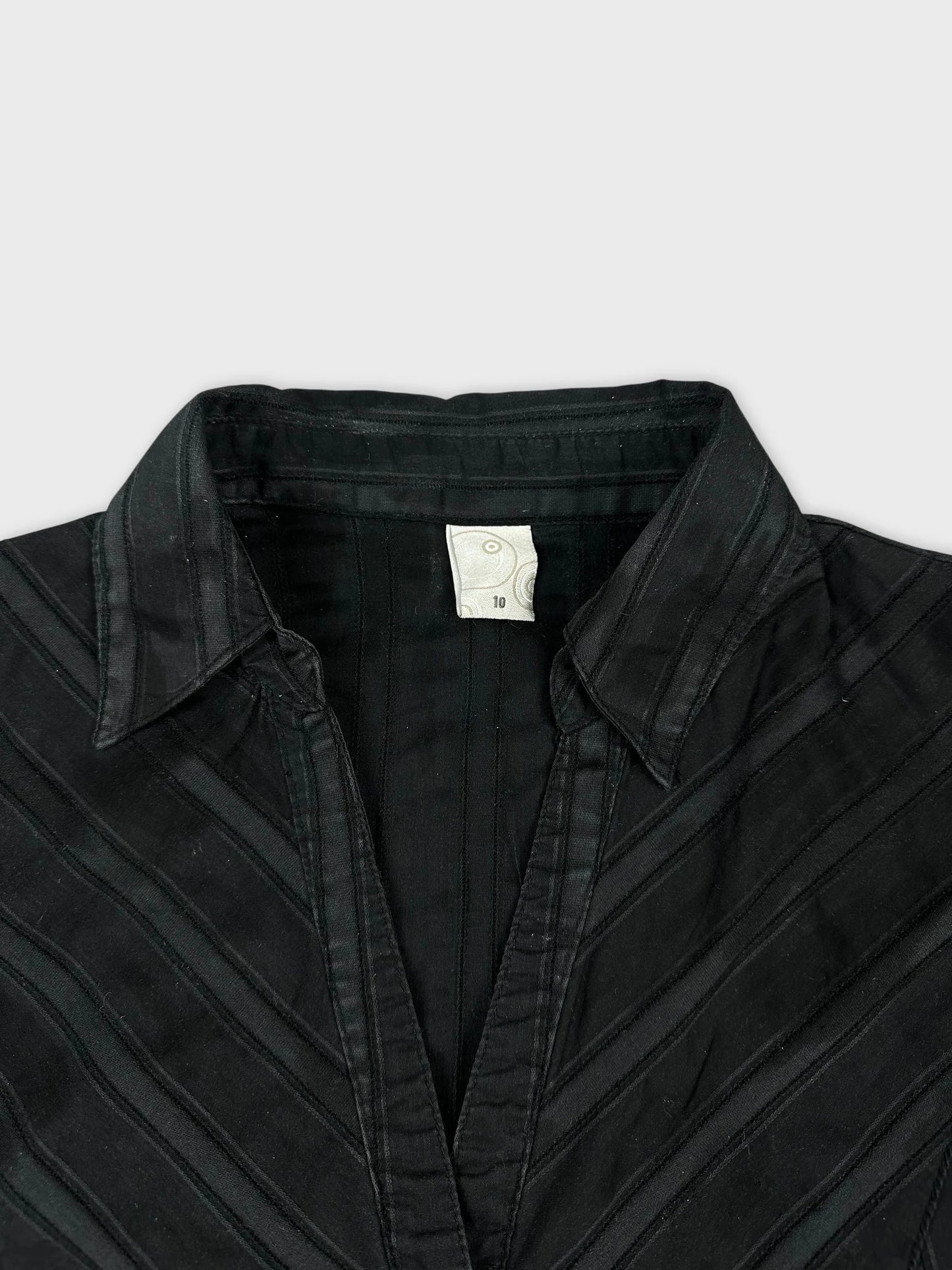 Detail view of a black women's short sleeve shirt with striped design.