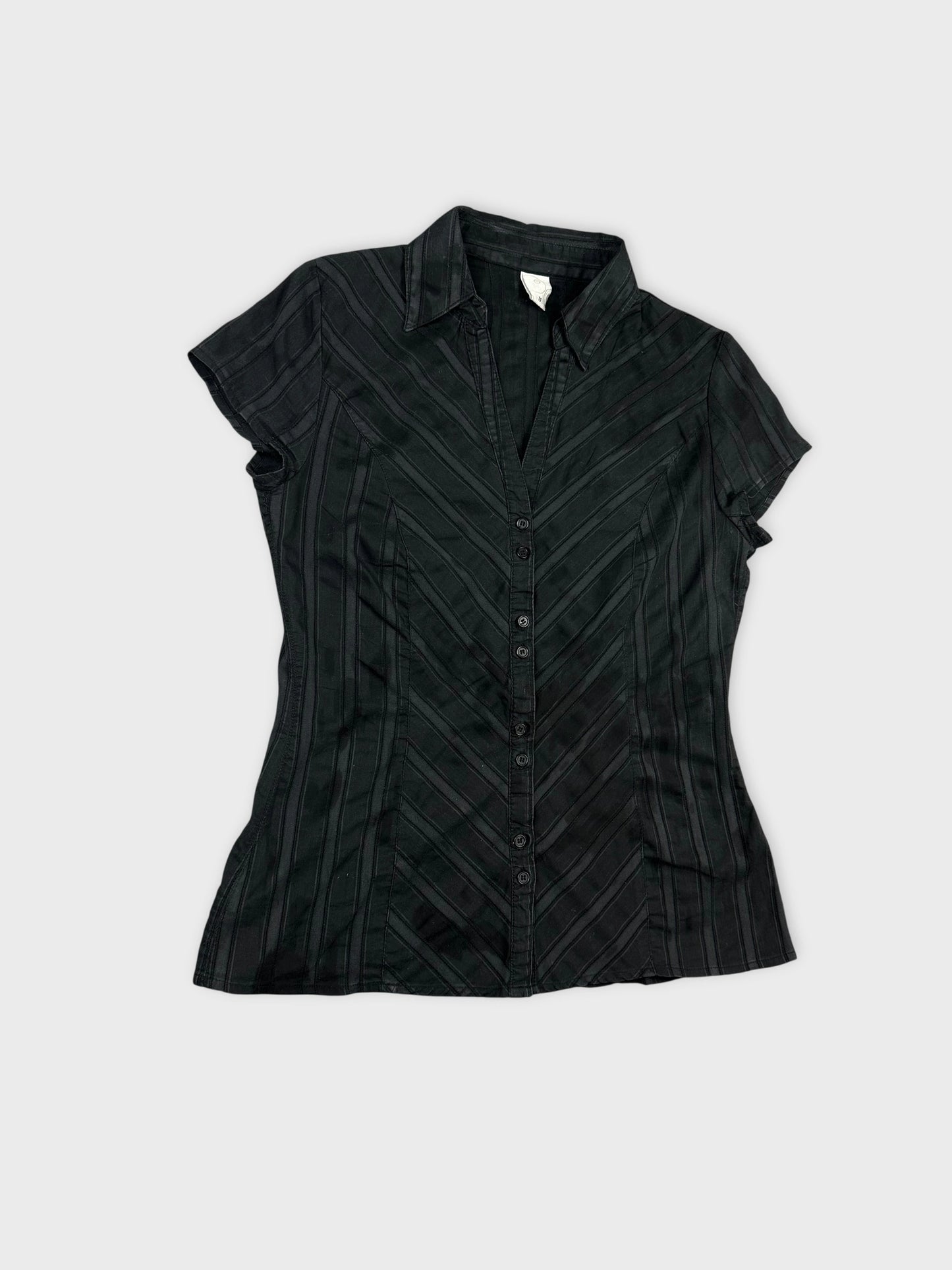 Detail view of a women's black short sleeve shirt featuring striped patterns.