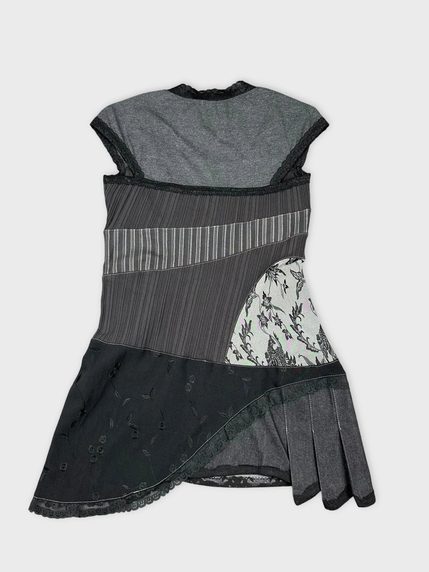 Back view of a short sleeve top in black with floral patterns and layered design.