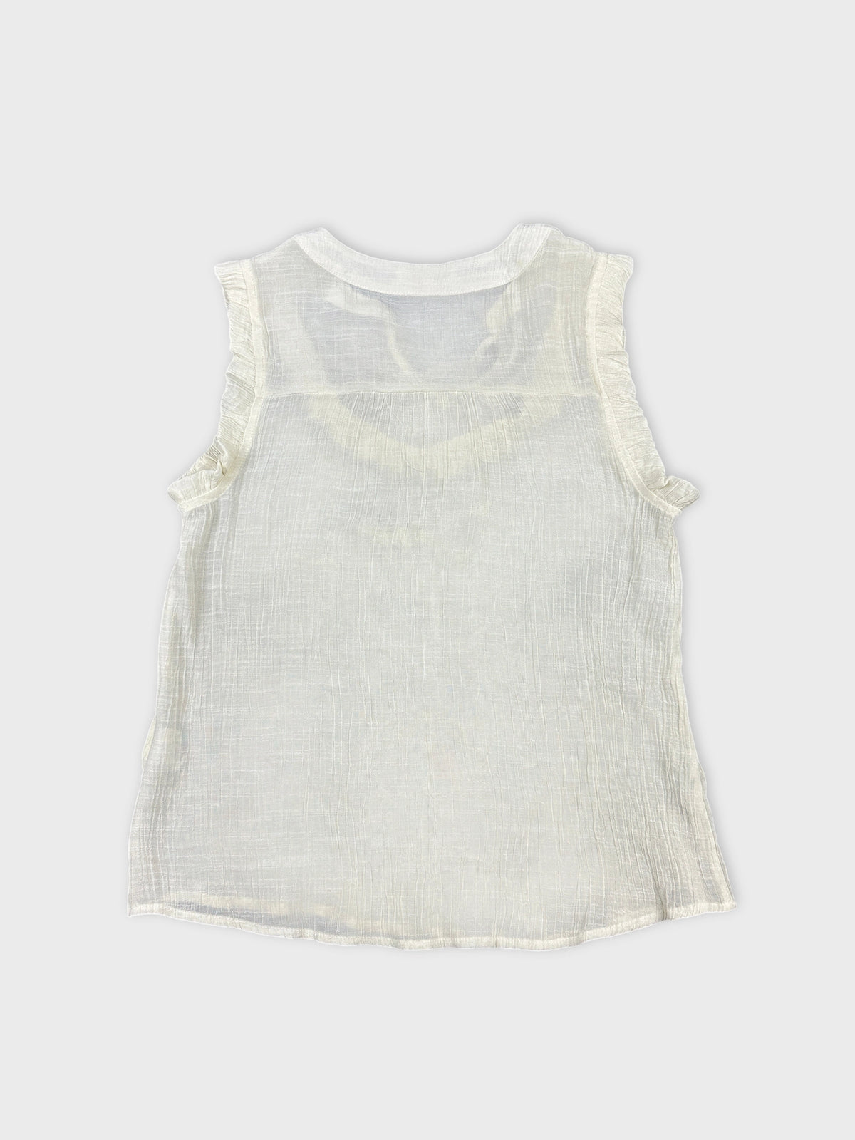 Back view of a sleeveless white top with ruffled trims.