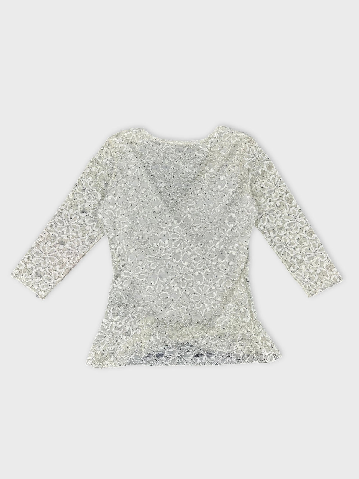 Back view of a white short sleeve top with floral lace pattern.