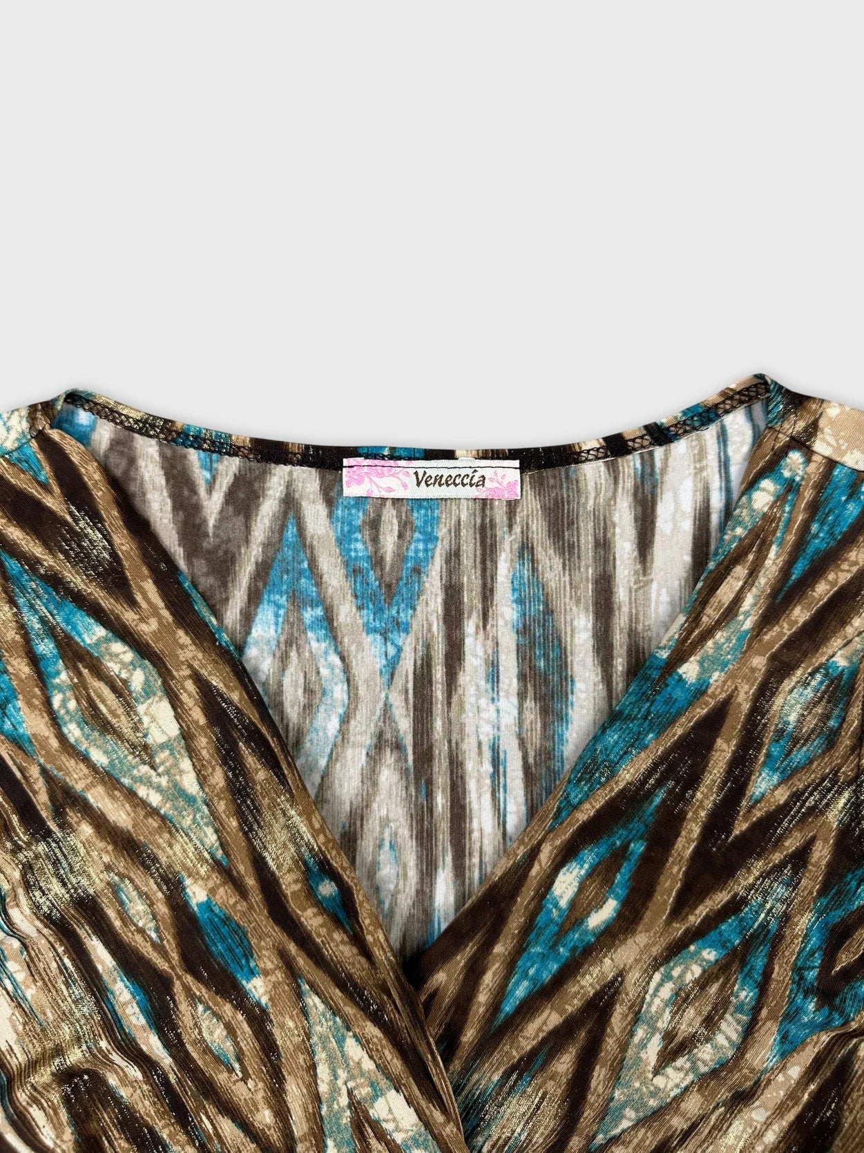 Detail view of a vintage short sleeve top with blue and brown geometric patterns.