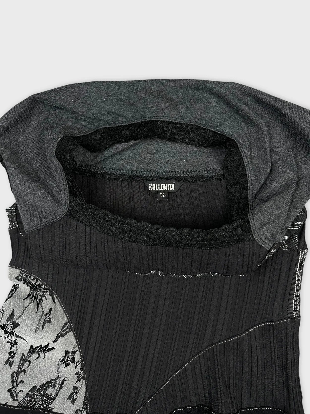 Detail view of a black short sleeve top featuring floral print and ribbed texture.