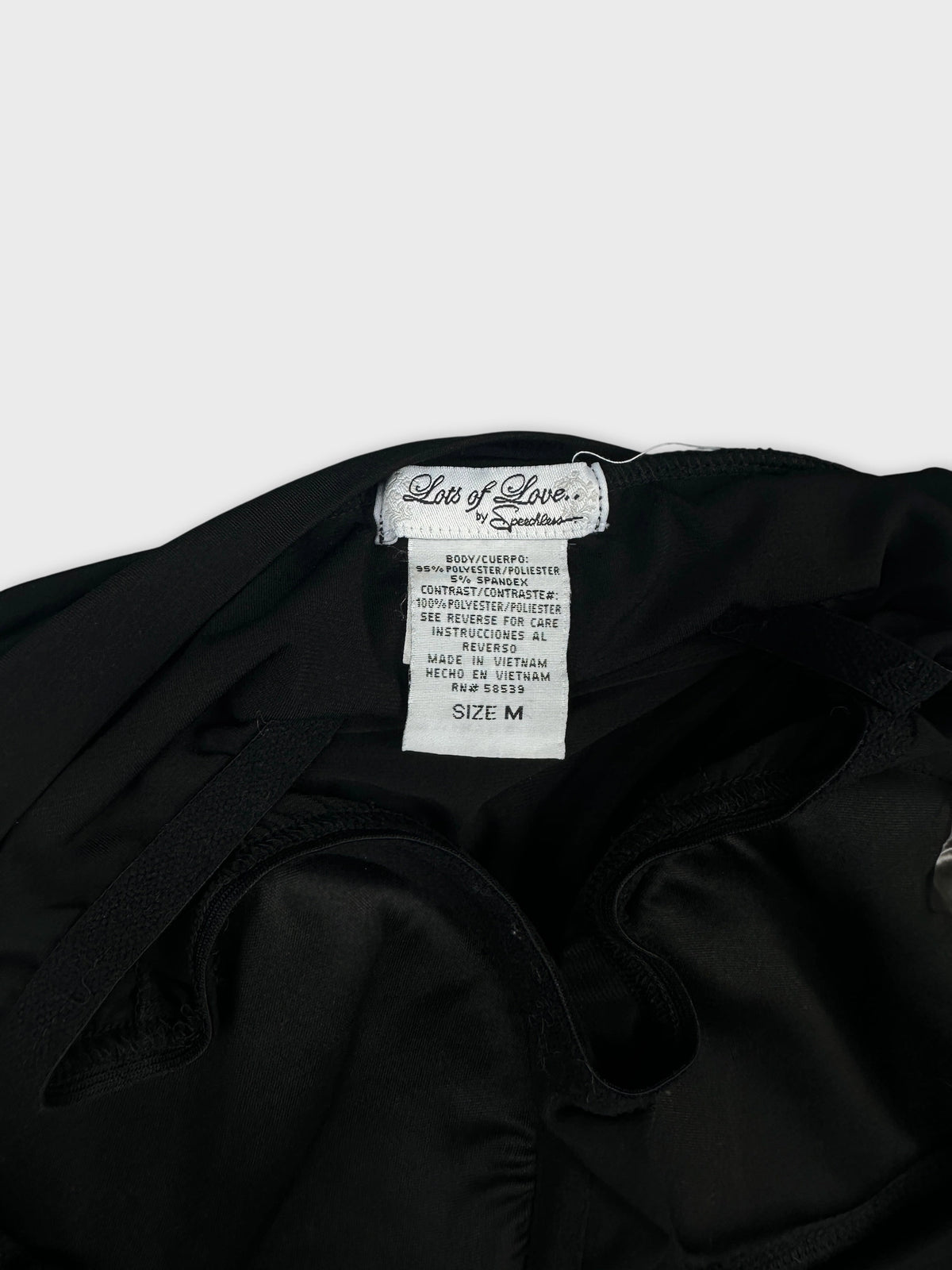 Detail view of women's black shorts sleeve tops with tag visible.