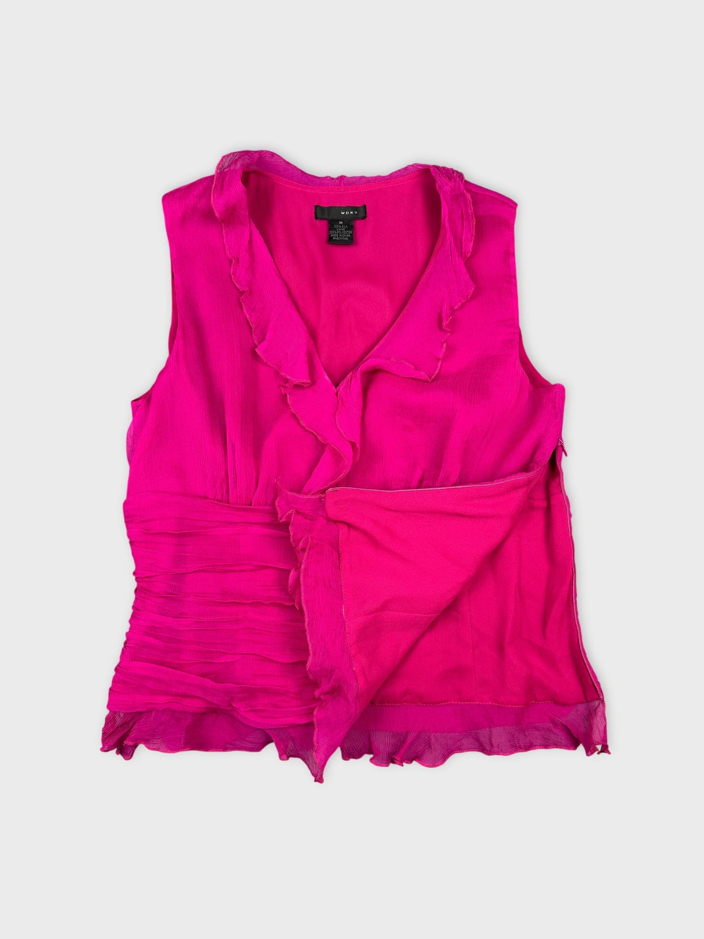 Detail view of a pink short sleeve top with ruffled neckline.