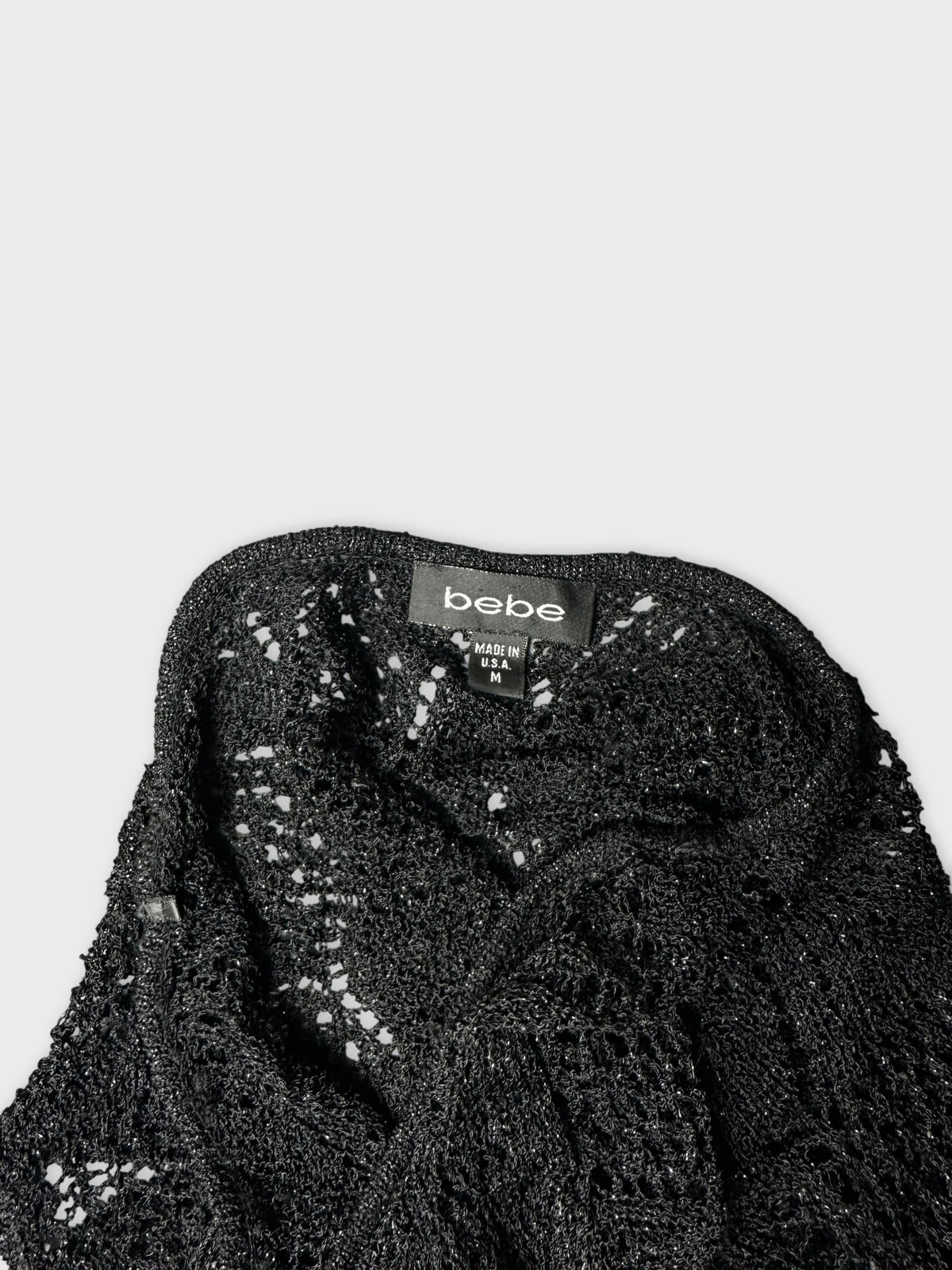 Detail view of a black short sleeve top with lace texture.