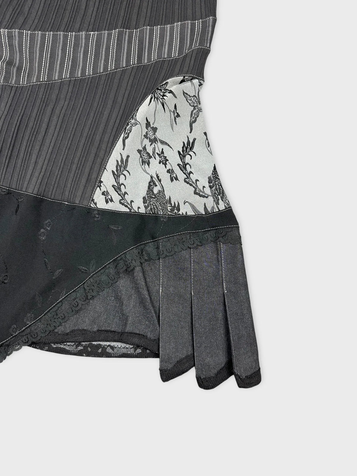 Detail view of a black women's top featuring pleats and floral print panel.