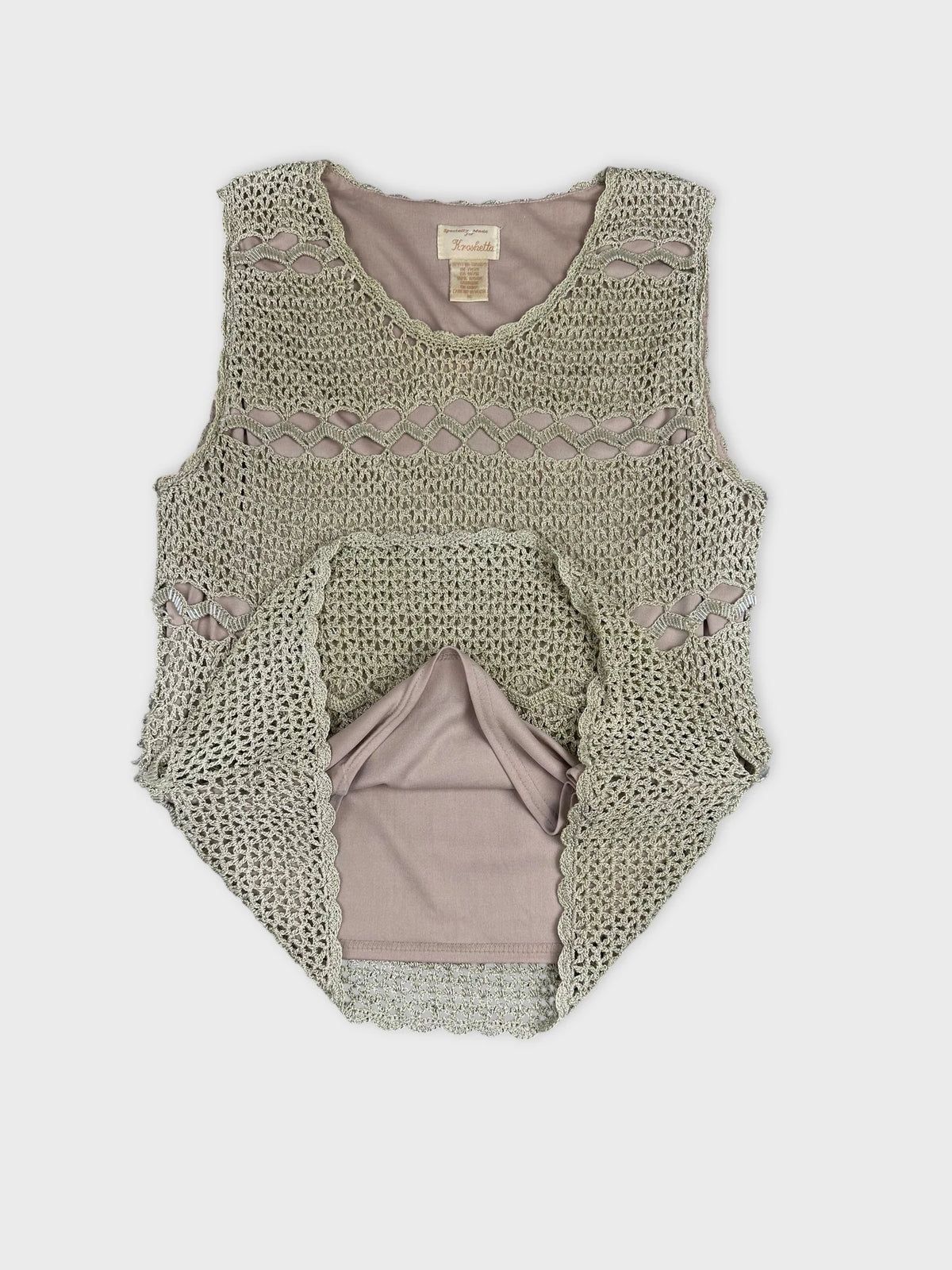 Detail view of a sleeveless olive green top with crochet pattern.