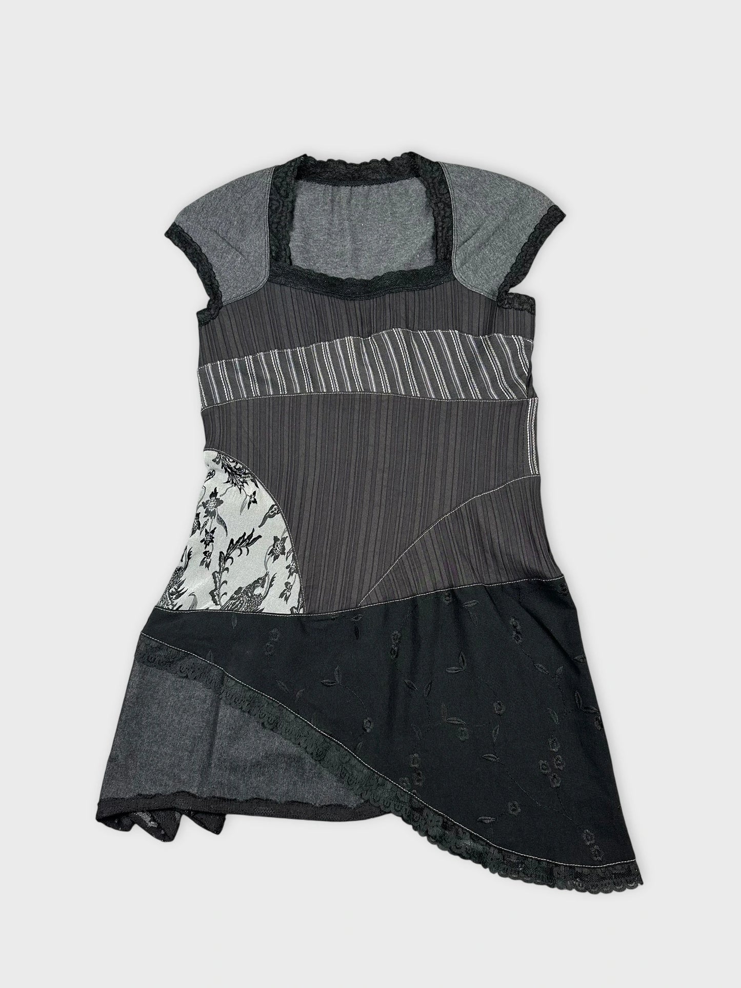 Front view of a black vintage top featuring mixed patterns and lace trim.