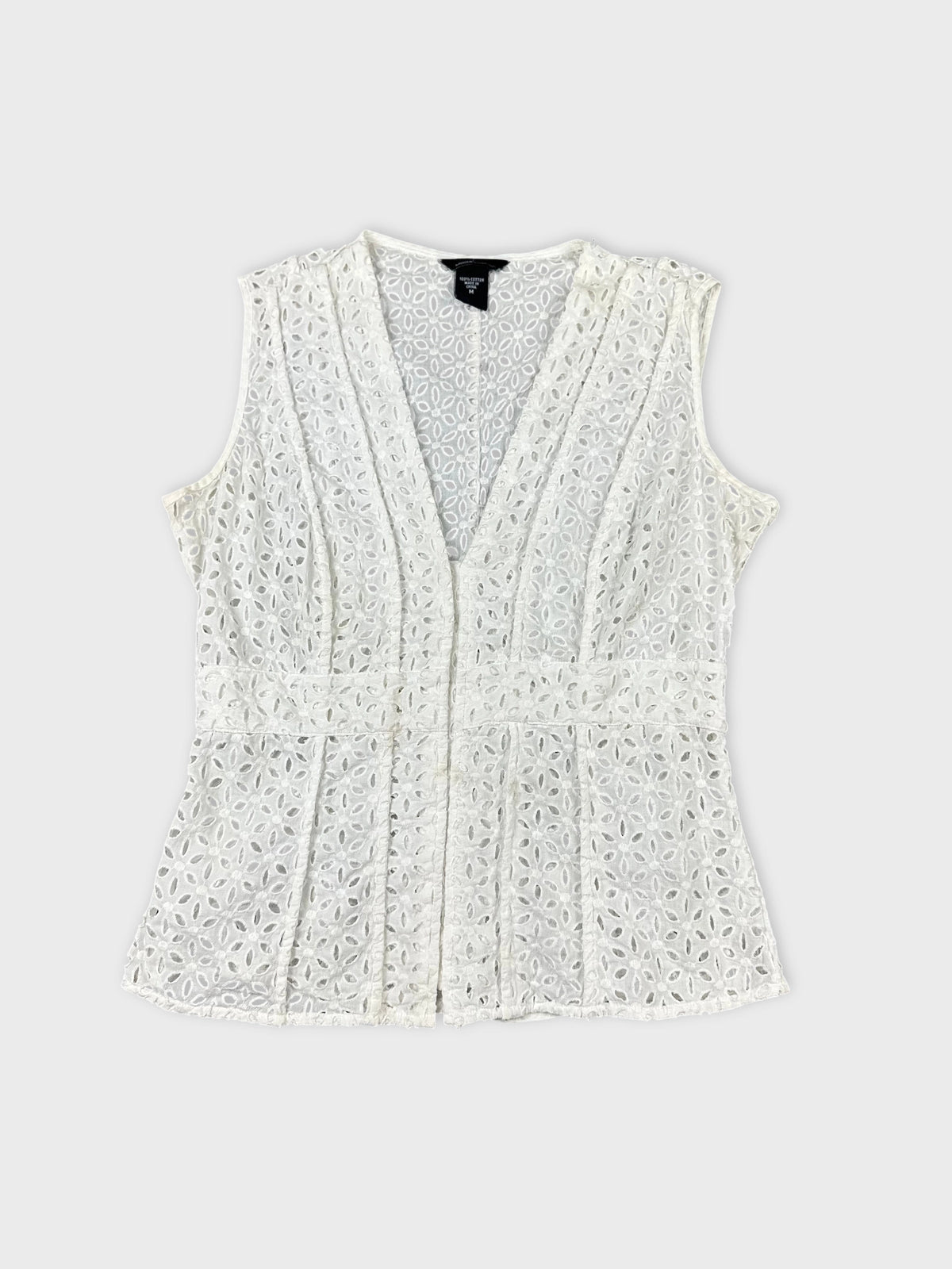 Front view of a white sleeveless top with floral lace pattern.