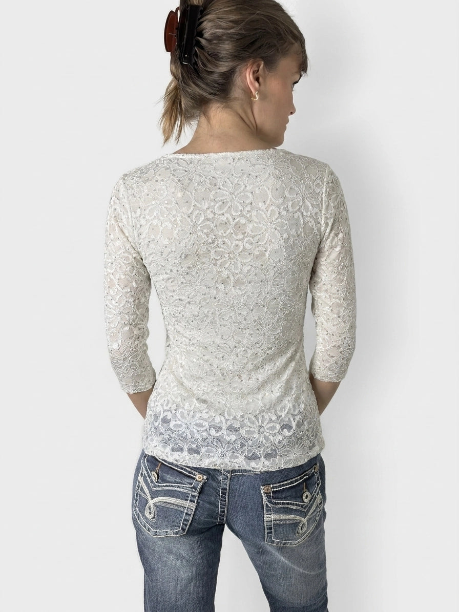Back view of a white lace women’s short sleeve top with floral pattern.