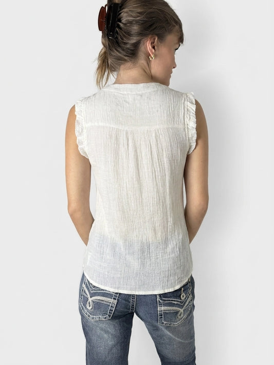 Back view of white short sleeve top with textured fabric and ruffled trim.