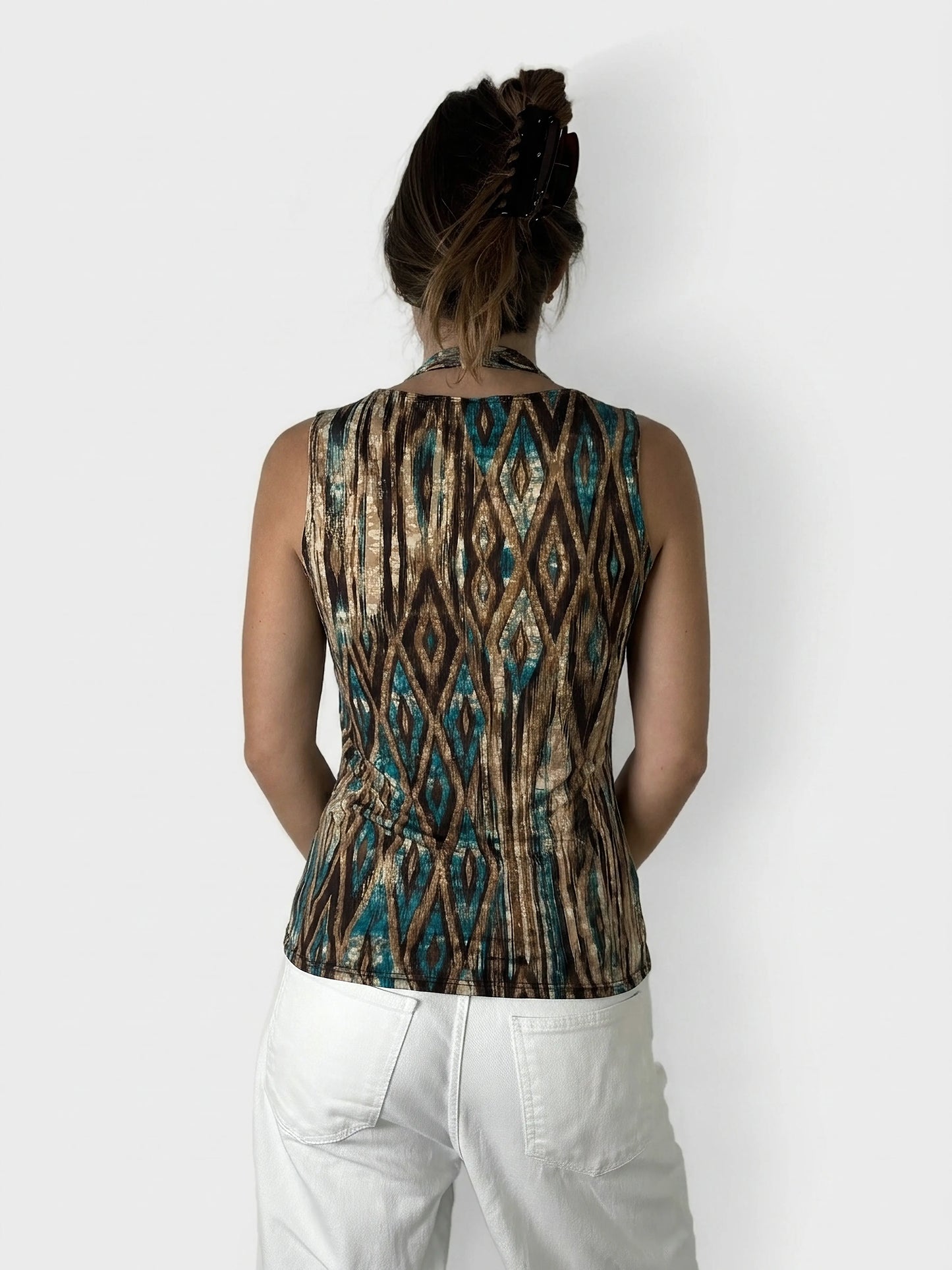 Back view of a sleeveless top, featuring a brown and turquoise geometric print.