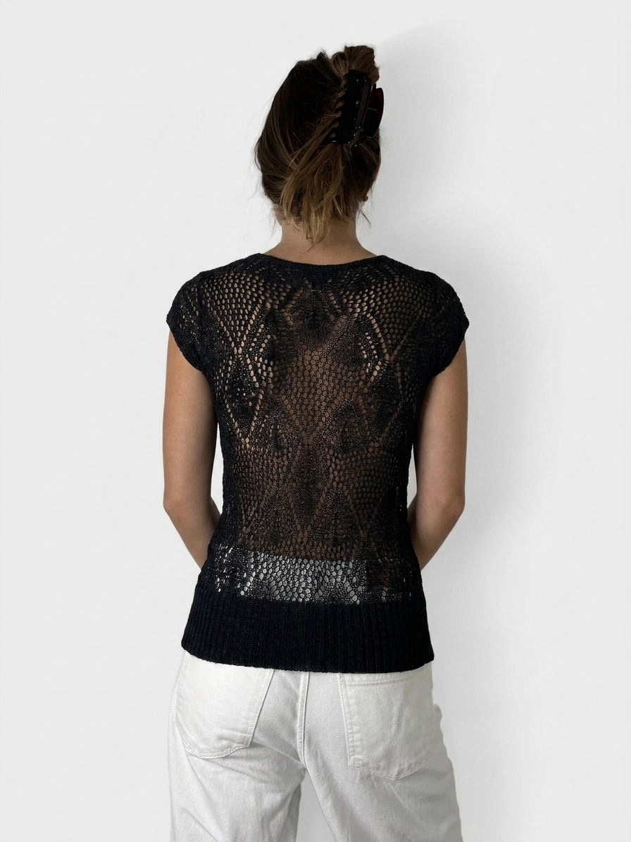 Back view of a black short sleeve top with a lace pattern.