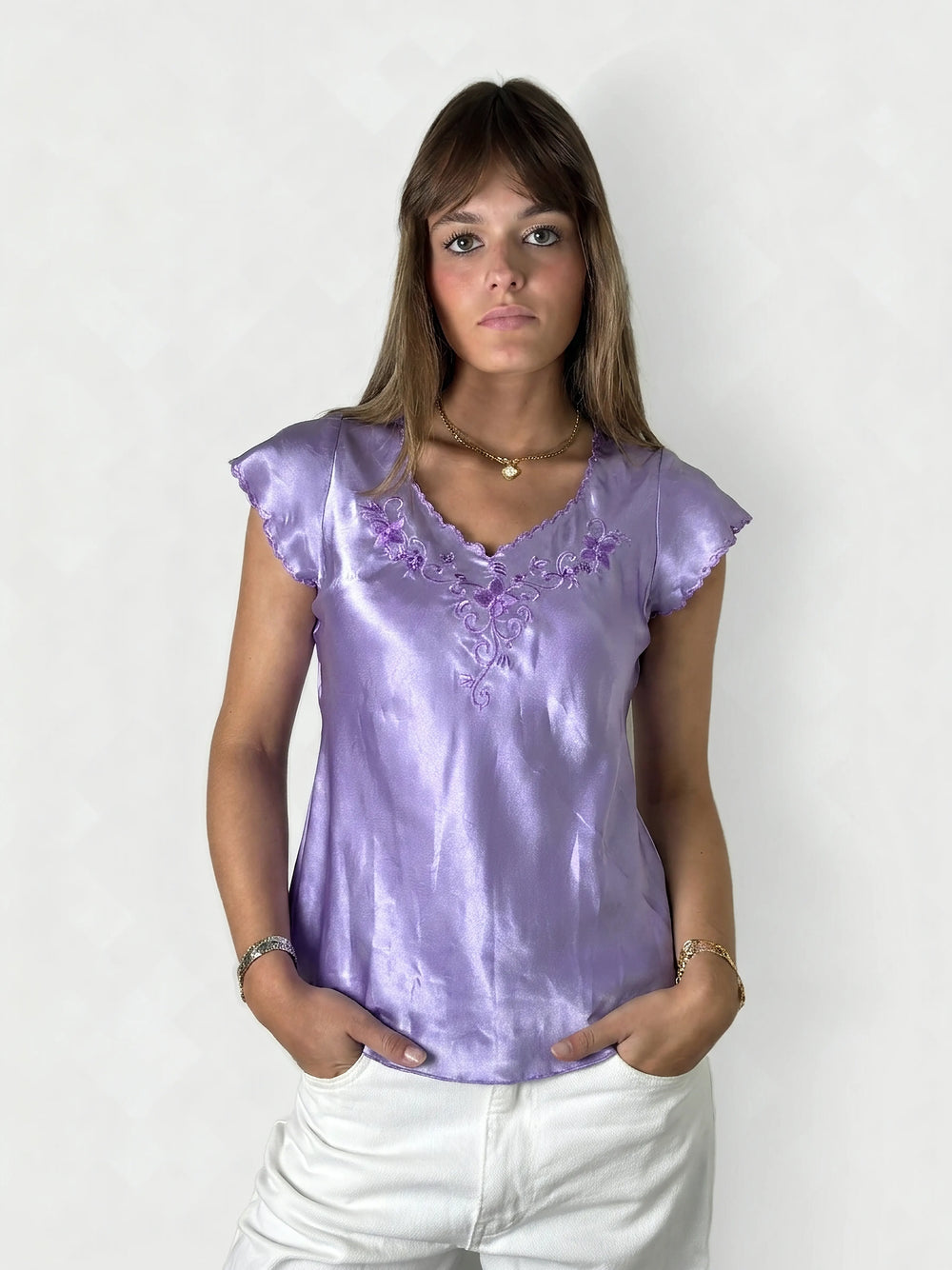 Front view of a short sleeve top in lavender with floral embroidery.