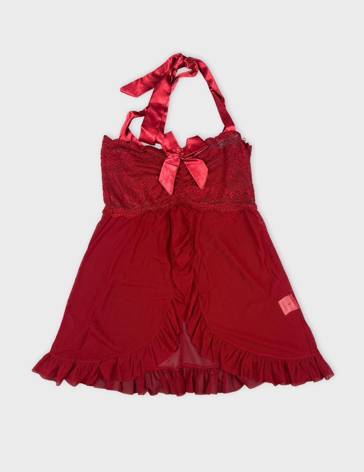 Front view of red halter top with lace trim and bow detail.