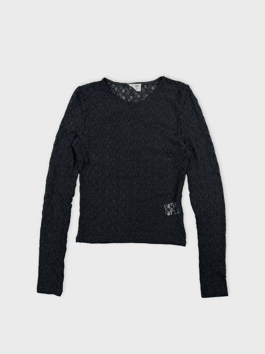 Front view of a black long sleeve top featuring intricate lace pattern.