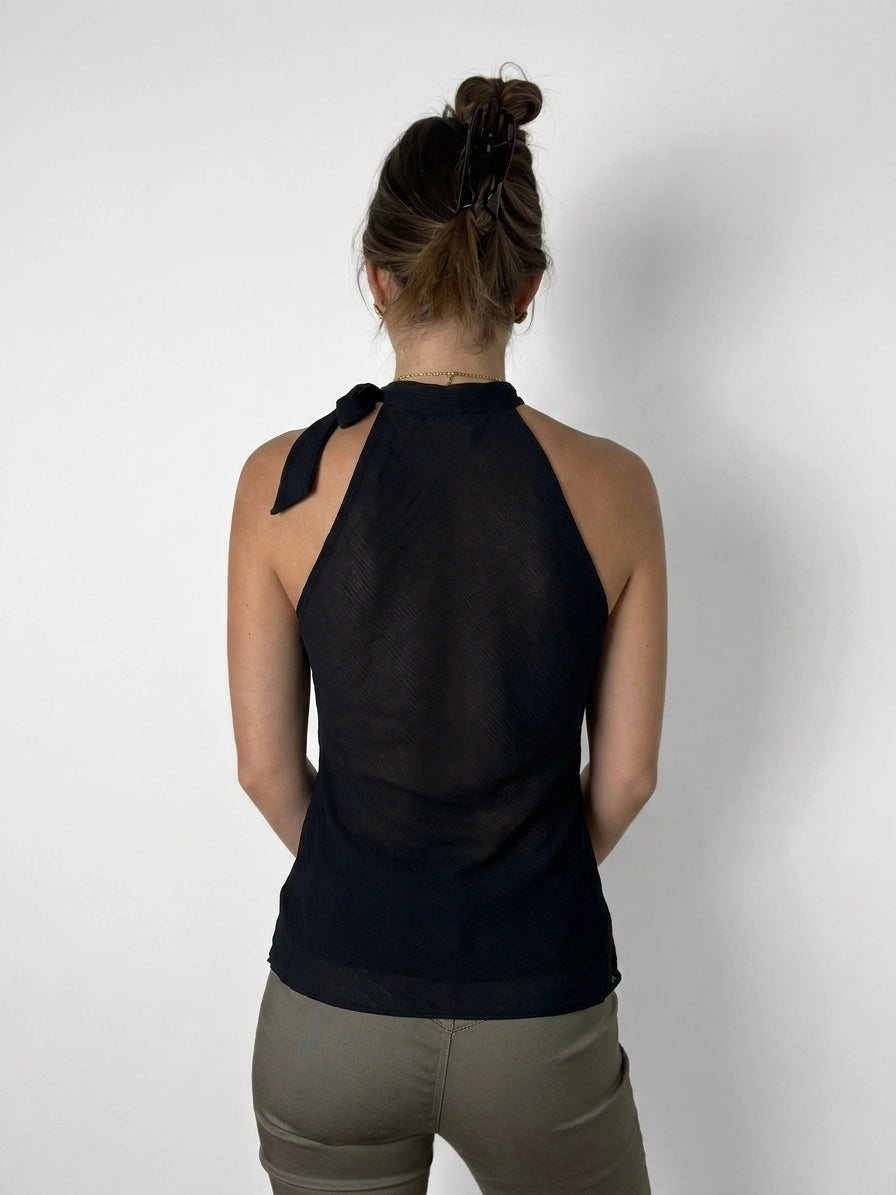 Back view of a black halter top with tie detail.