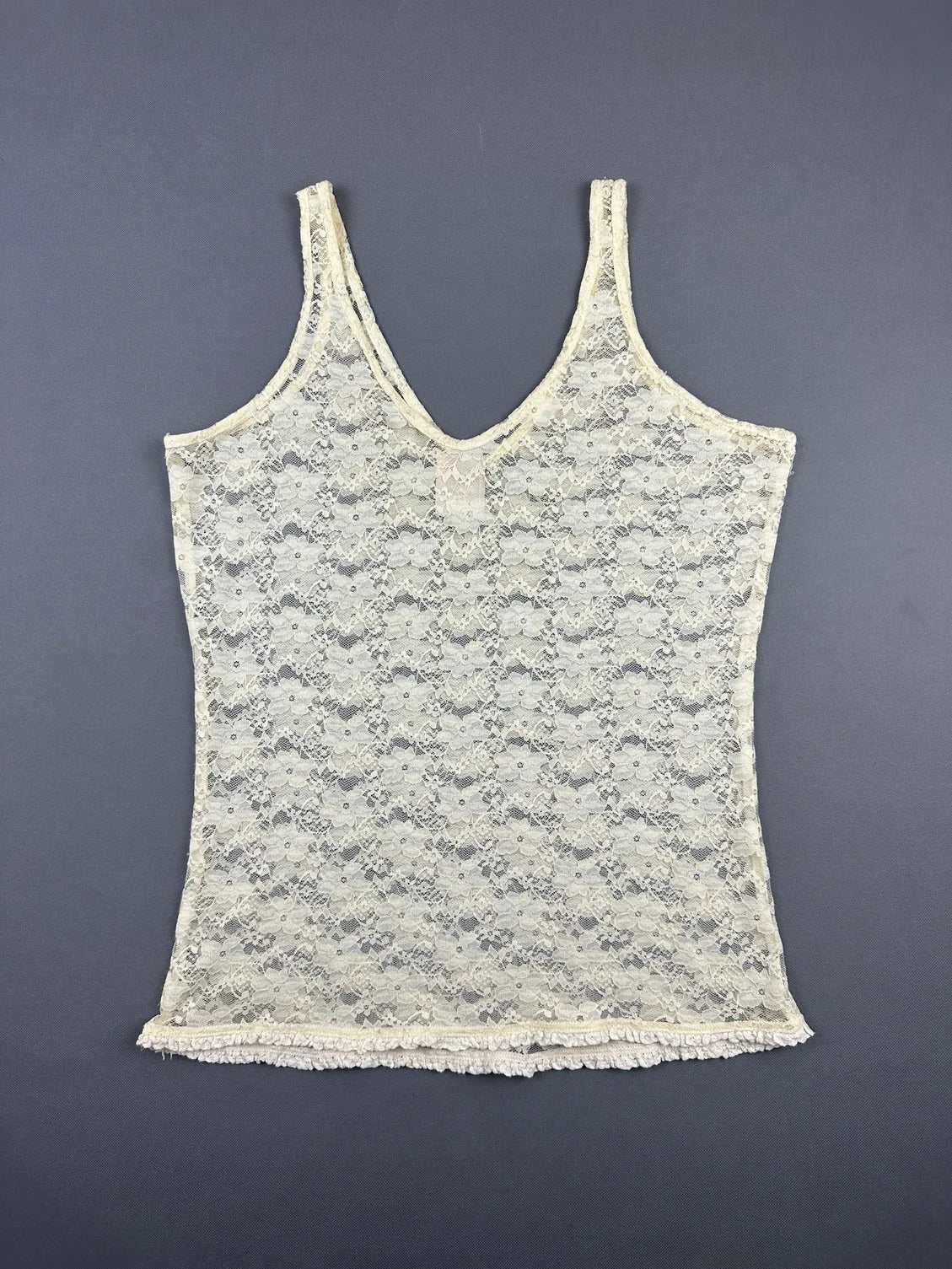 Back view of a vintage lace tank top in cream color with decorative trim.
