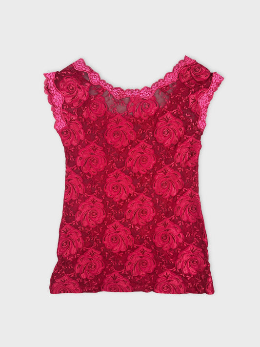 Back view of a red floral lace top featuring scalloped trim.