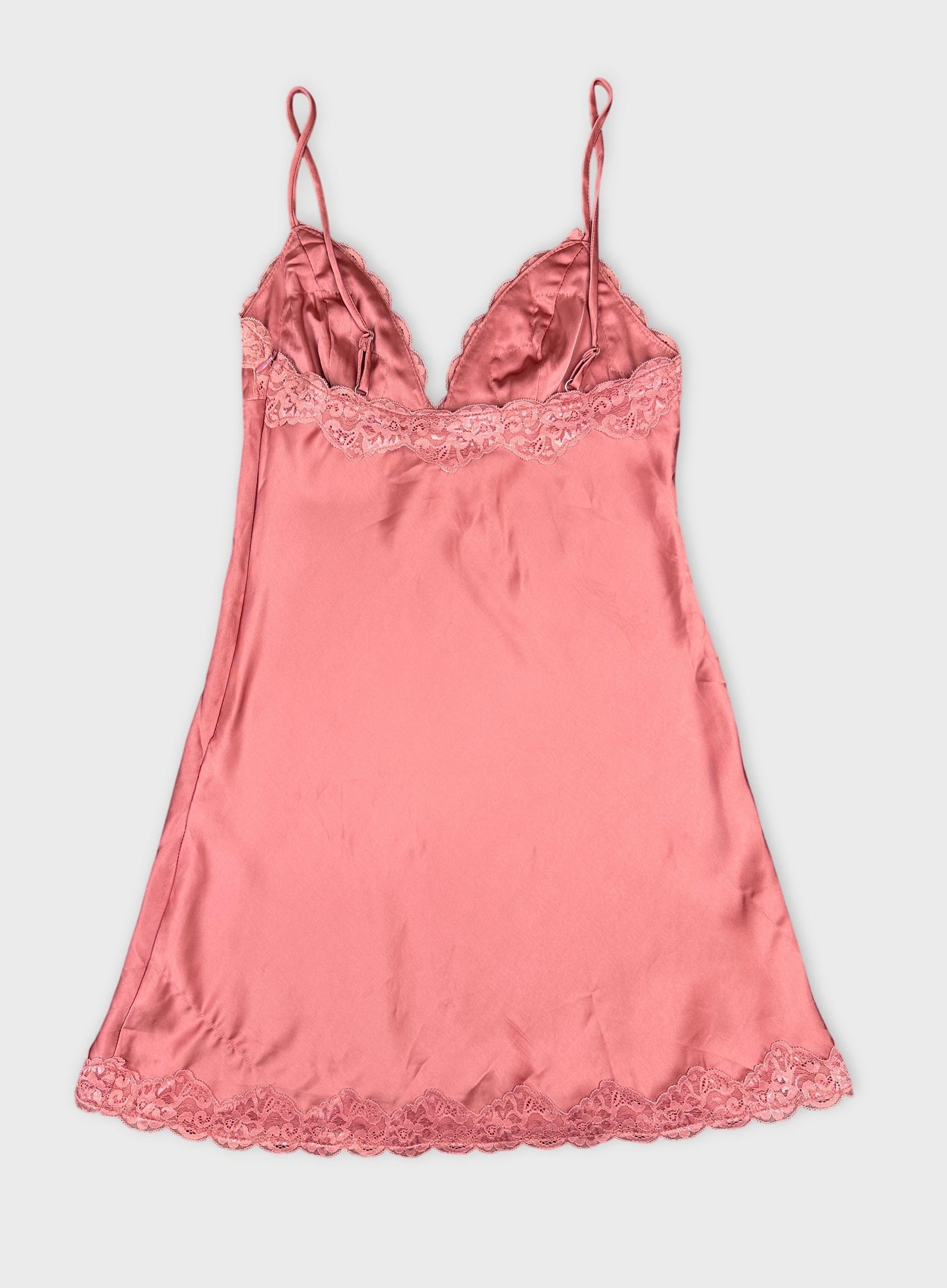Back view of a pink satin camisole with lace trim.