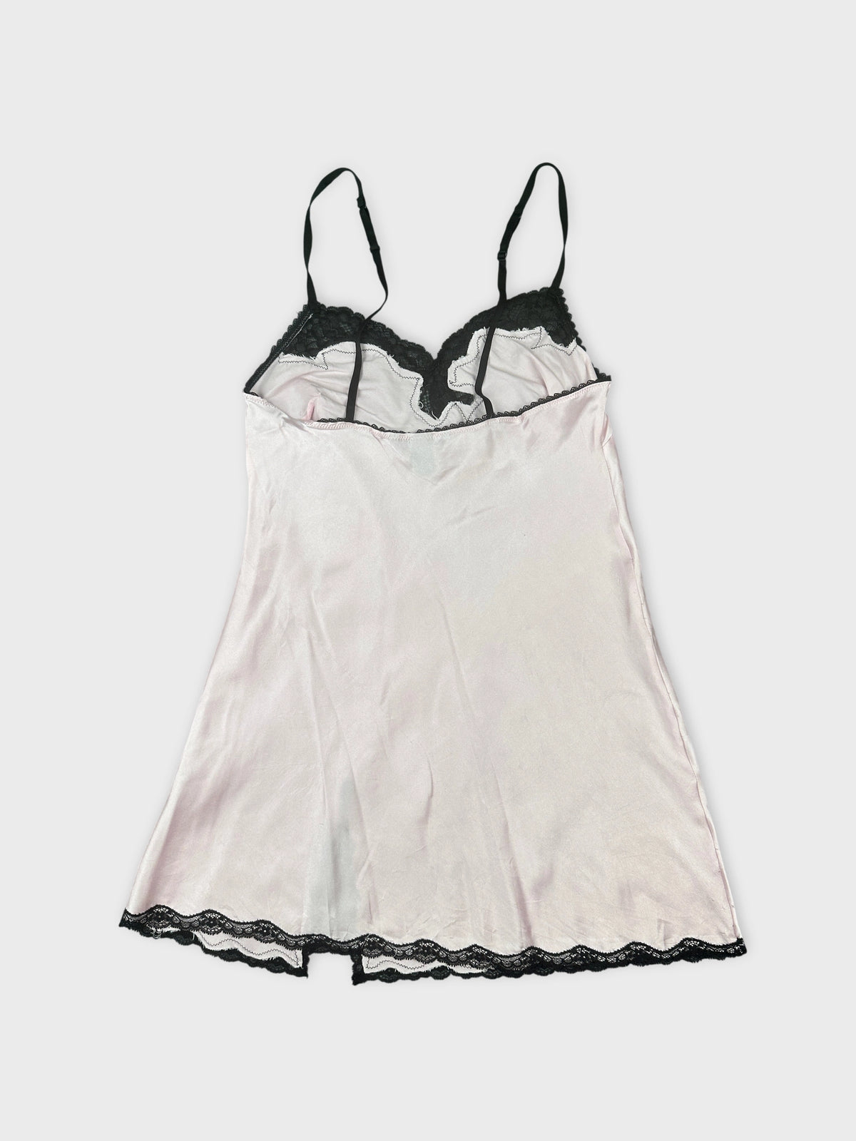 Back view of a pink vintage top with black lace trim.