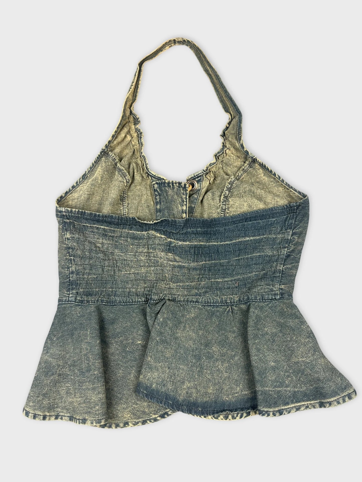 Back view of a denim peplum top with ruffled straps.