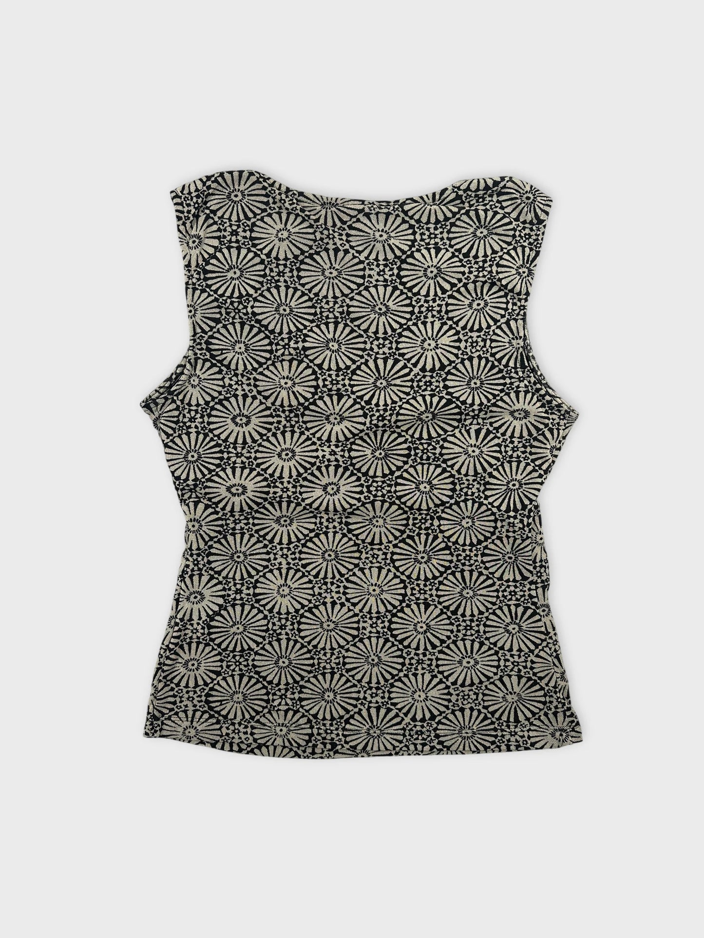 Back view of a sleeveless top in black and cream with floral pattern.