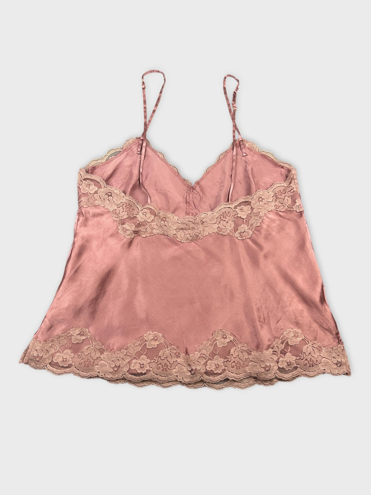 Back view of a pink satin camisole with lace trim.