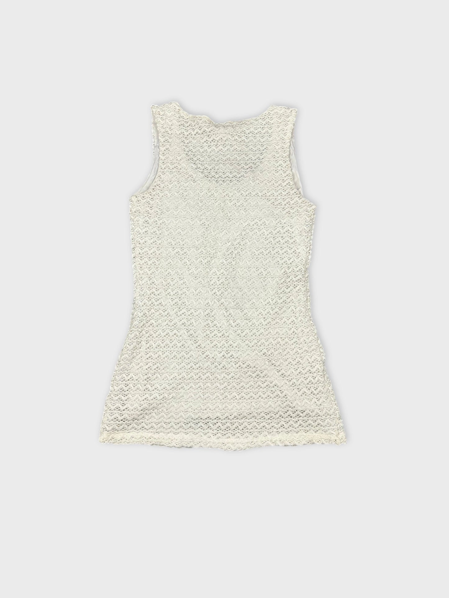 Back view of a white lace tank top featuring a scalloped edge.