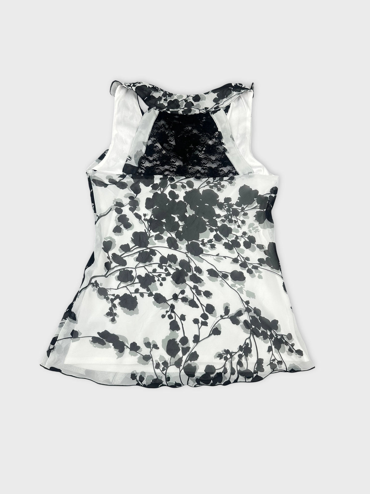 Back view of a sleeveless top in black and white floral pattern.