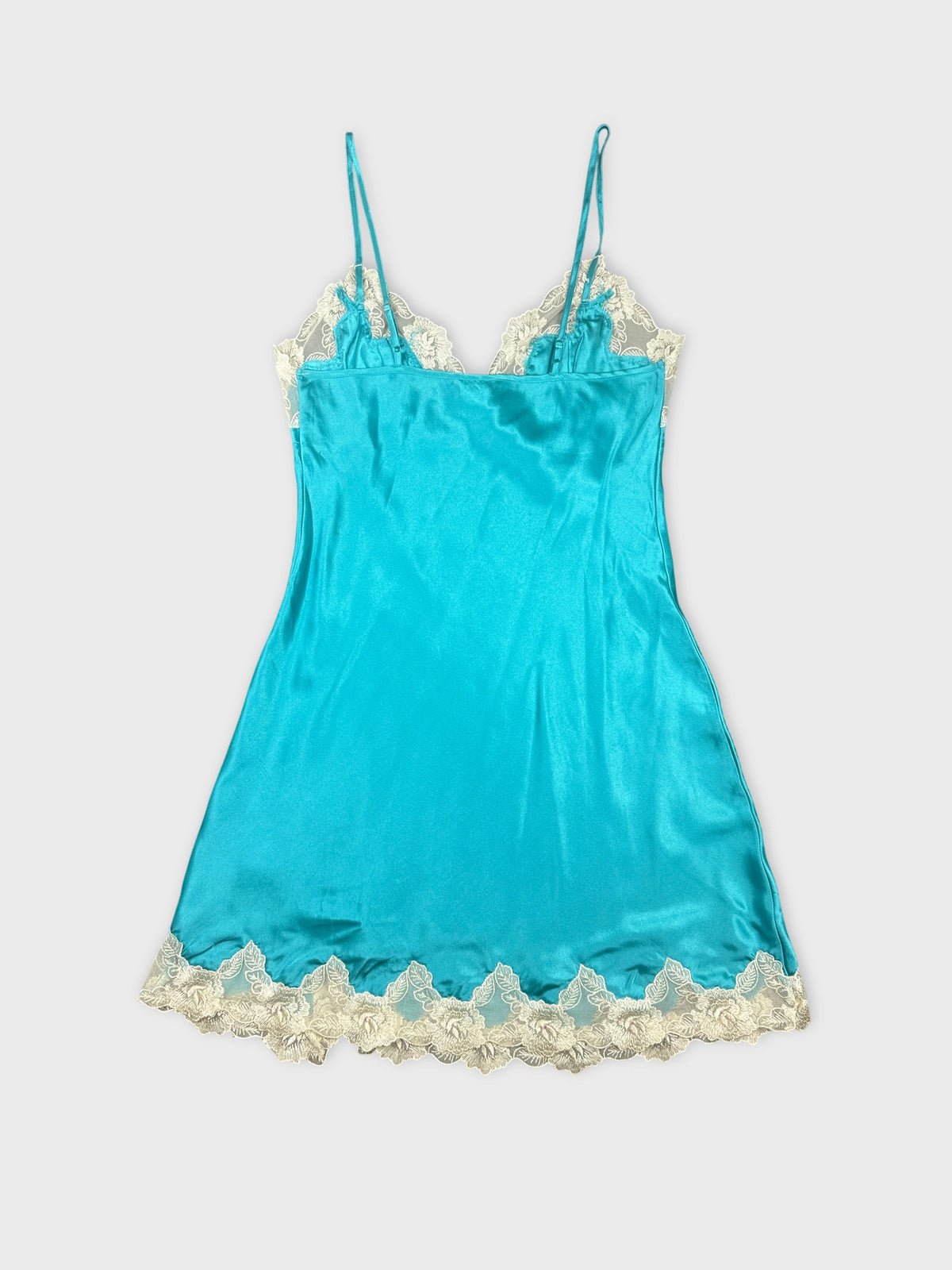 Back view of a turquoise slip top featuring lace trim.