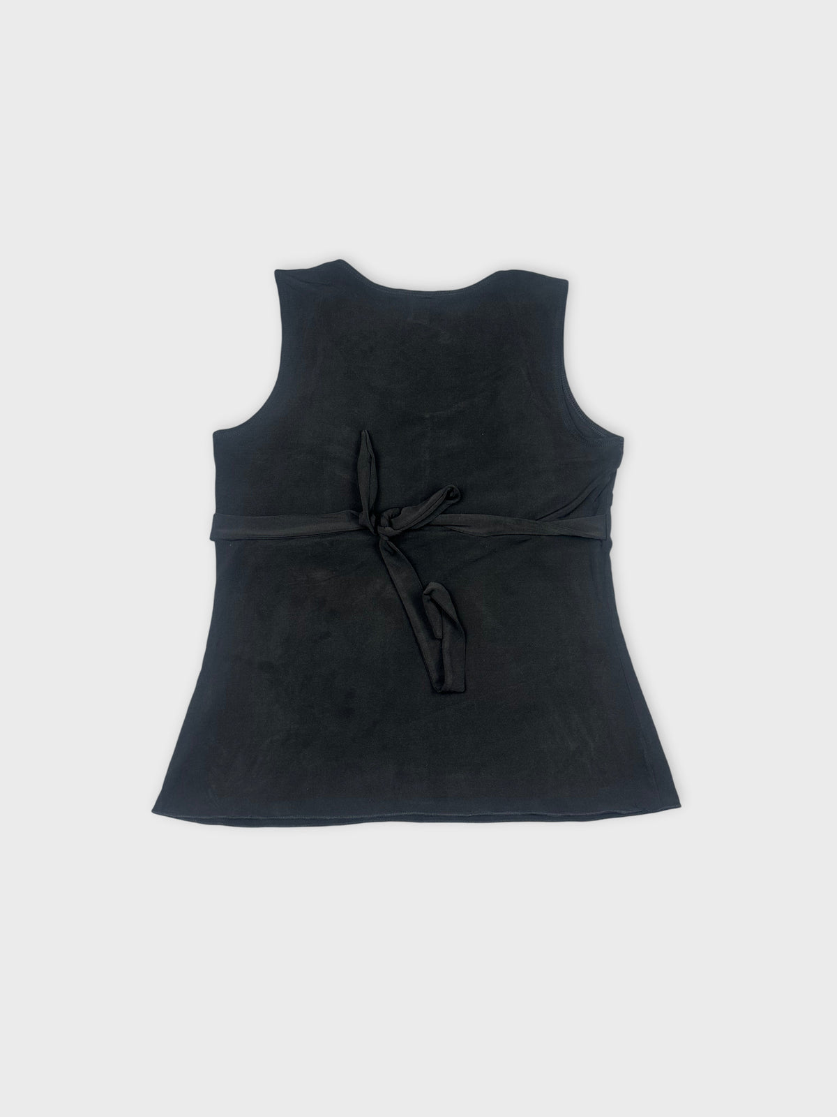 Back view of a black sleeveless top with a tied waist detail.