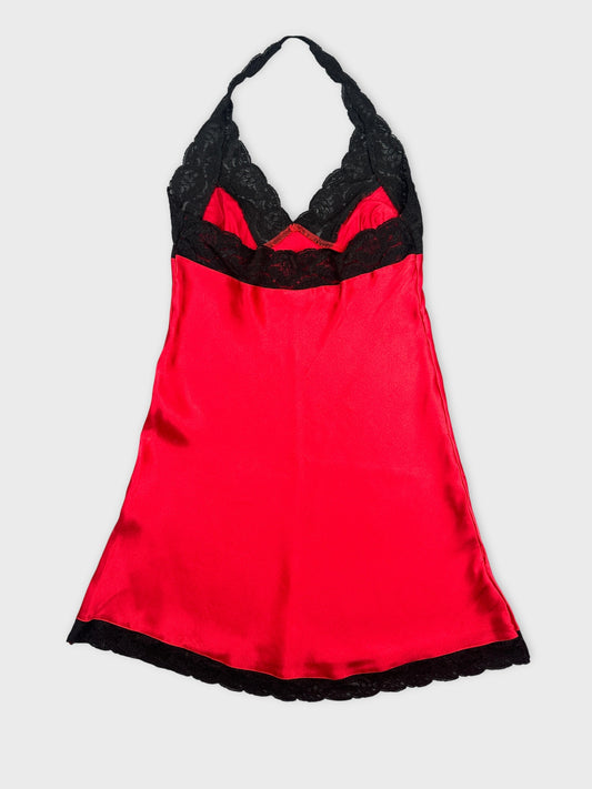 Back view of a red satin camisole with black lace trim.