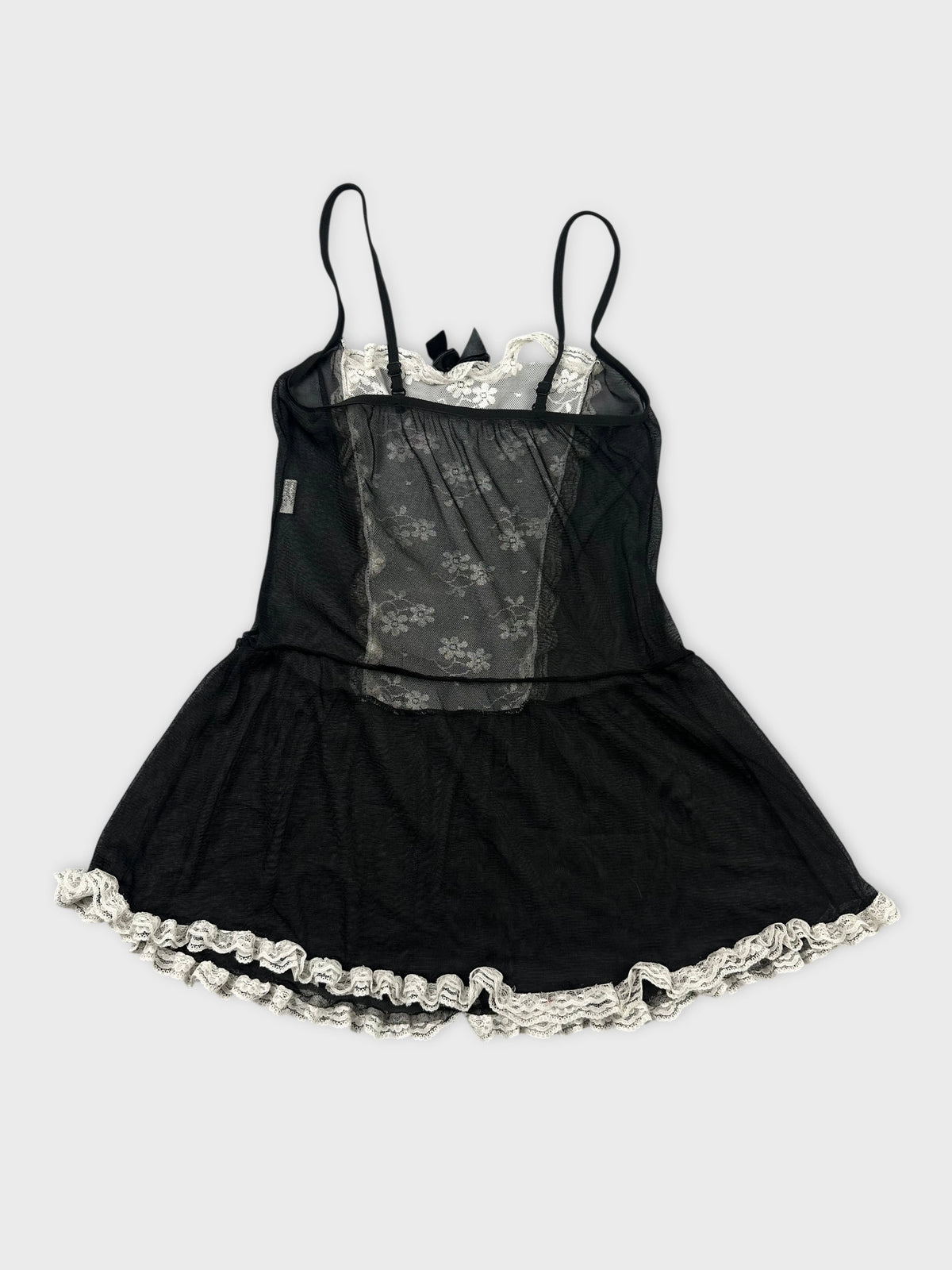 Back view of a black vintage top with lace trim and floral pattern.