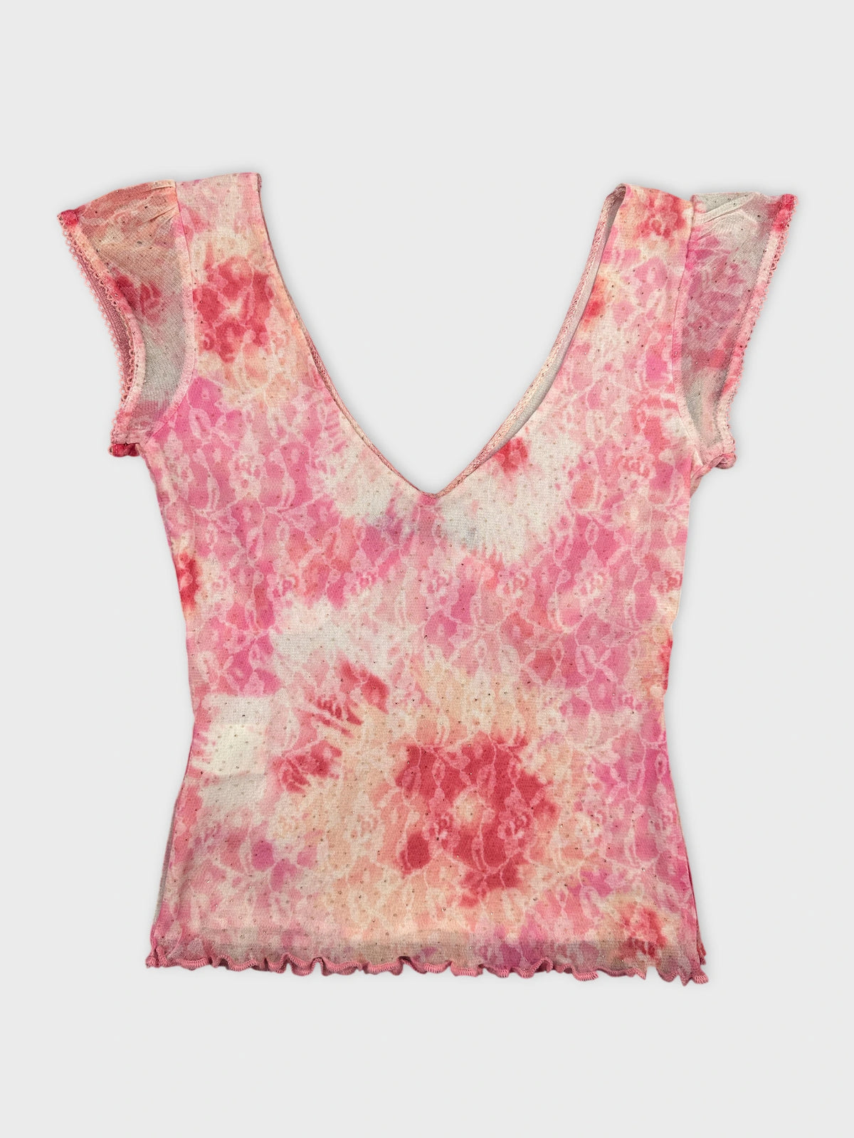 Back view of a pink floral vintage top with scalloped trim.