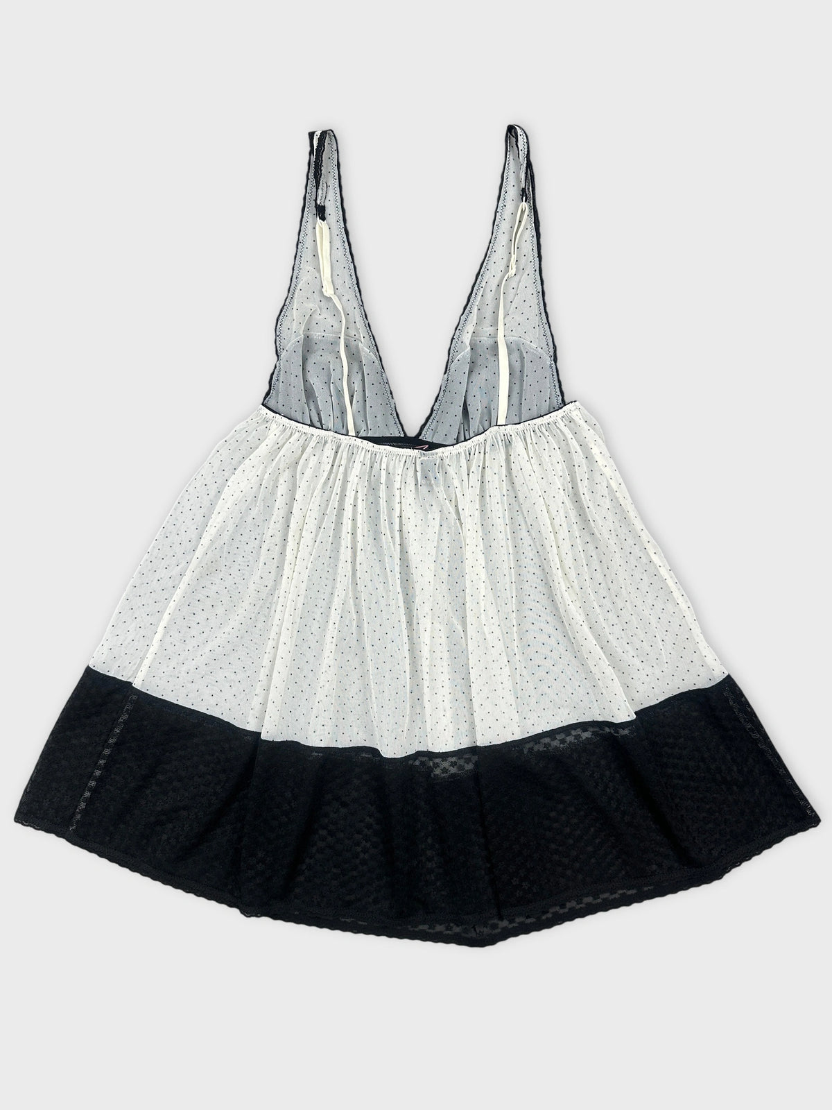 Back view of a women's vintage top with polka dots in white and black.