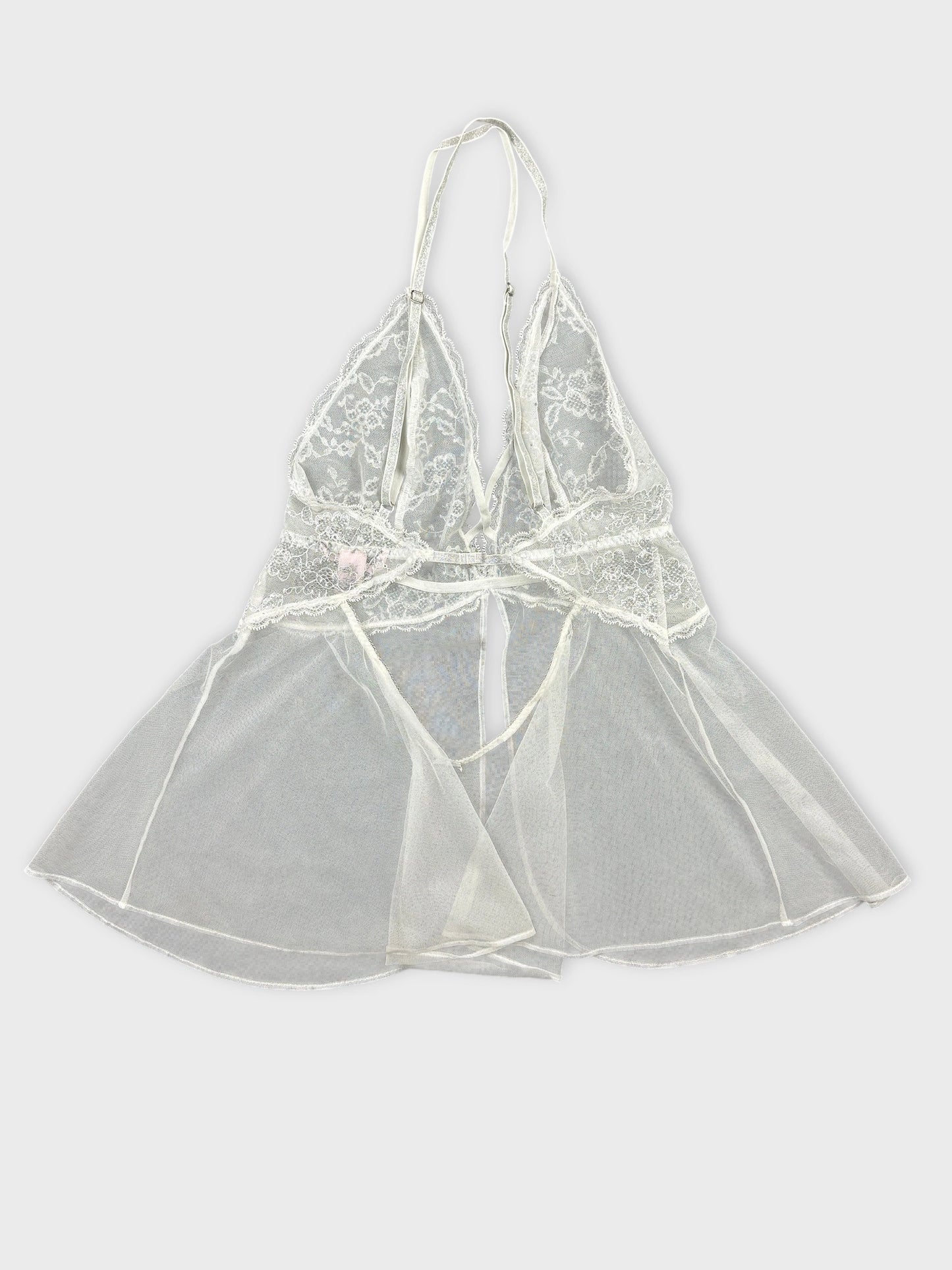 Back view of a light ivory lace top featuring a sheer tulle hem.