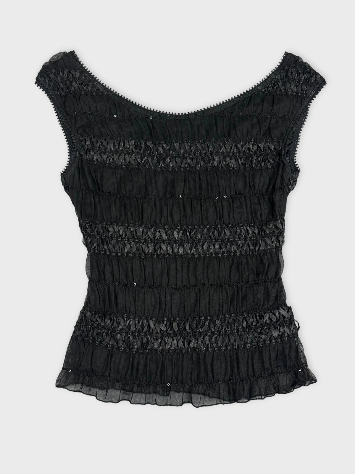 Back view of a black woman’s top featuring ruffled texture and detailing.