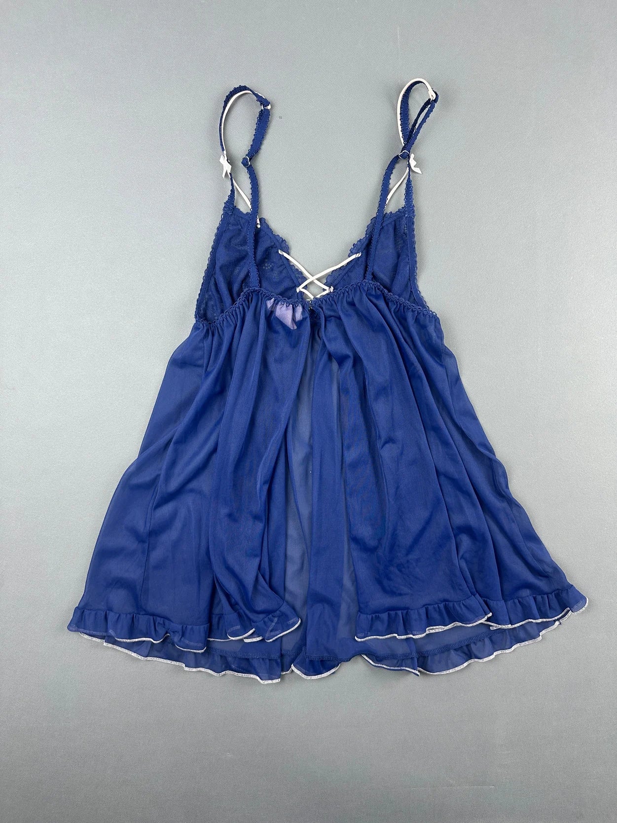 Back view of a navy blue upper body top with delicate lace trim.