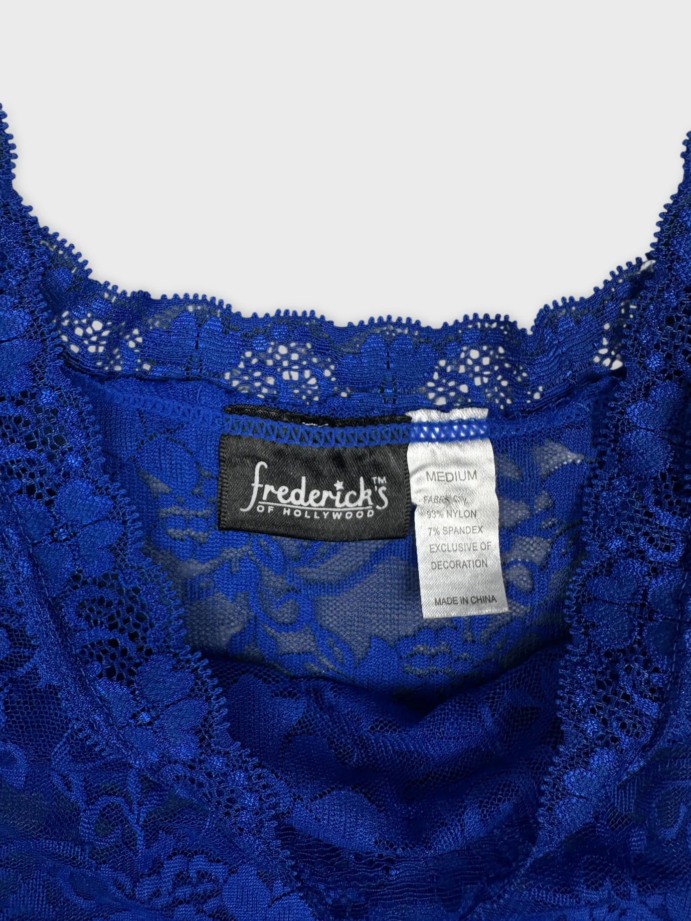Detail view of a blue lace women's top with scalloped trim.