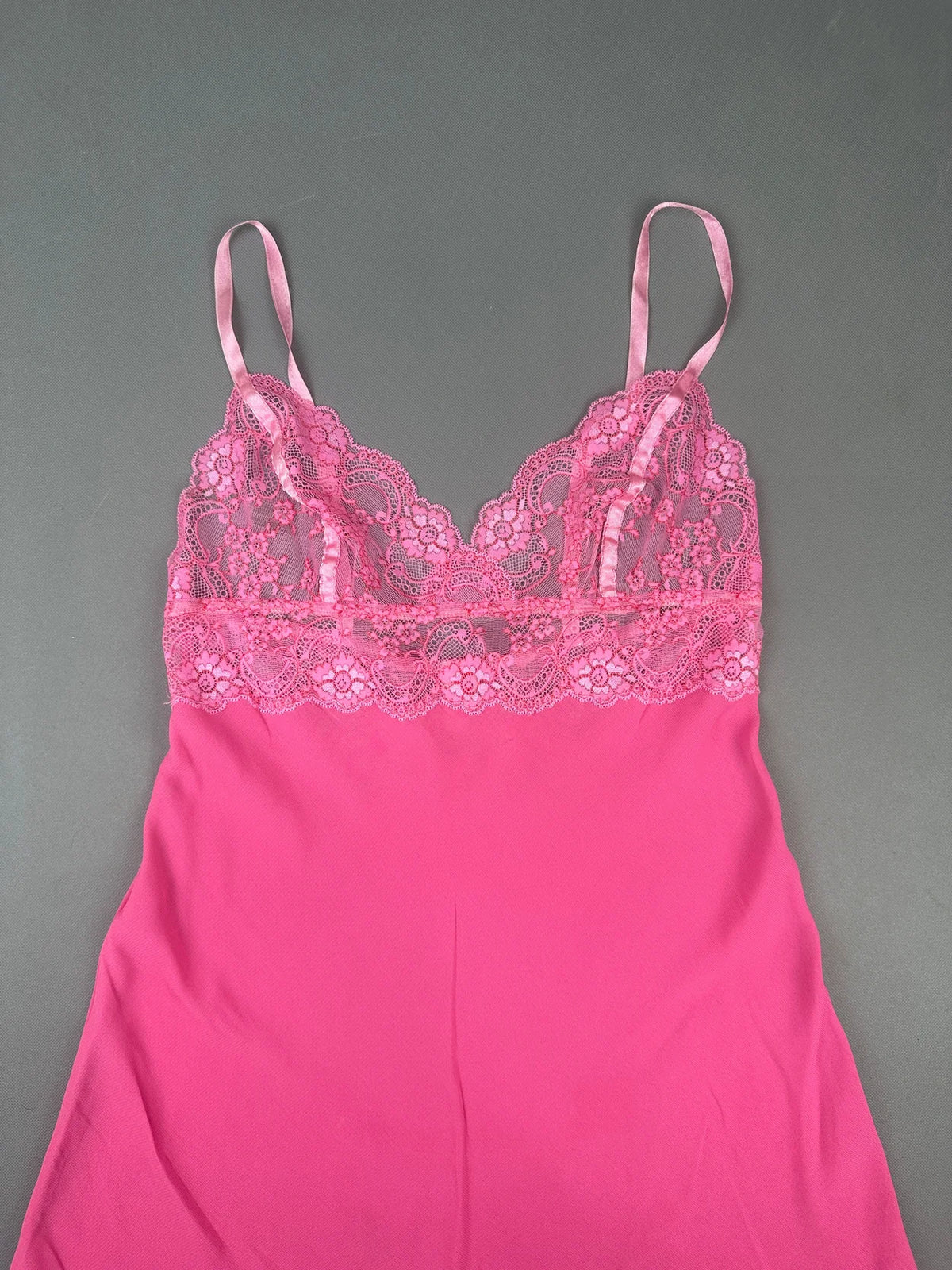 Detail view of a pink lace-trimmed camisole top with adjustable straps.